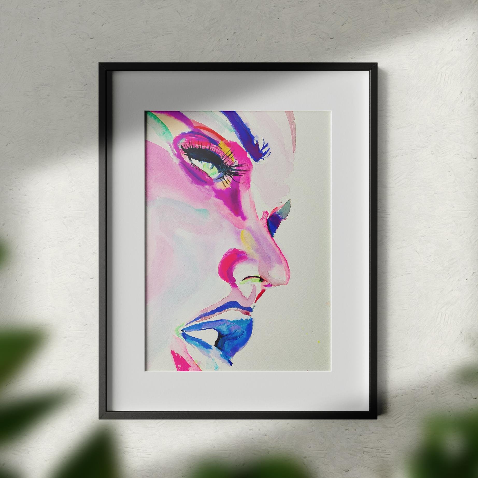 Framed Copacabana watercolor painting in a modern black frame with matting, placed against a white wall with soft light and blurred greenery in the foreground.