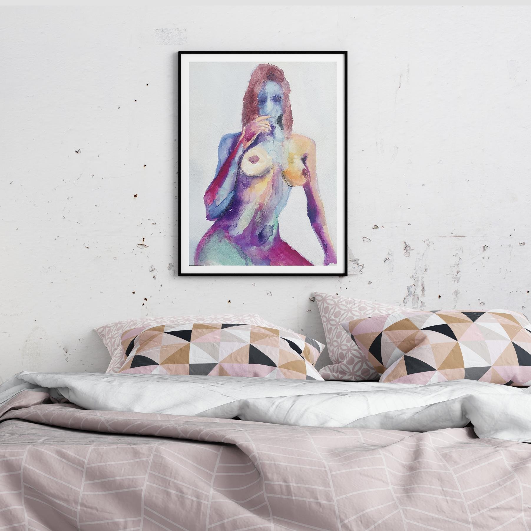 Colorful nude watercolor art print displayed in a minimalist bedroom setting with soft pastel bedding and a raw textured wal