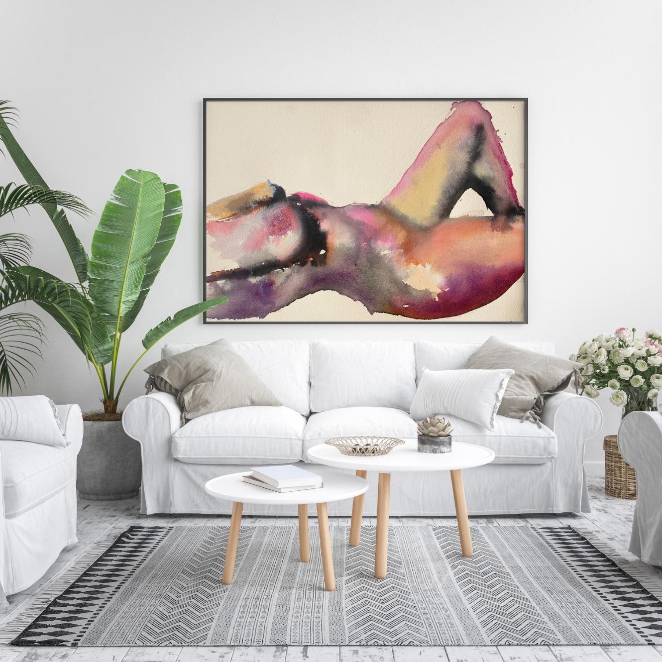 Colorful nude watercolor painting “Sérénité” displayed in a chic white living room with plants and neutral decor.