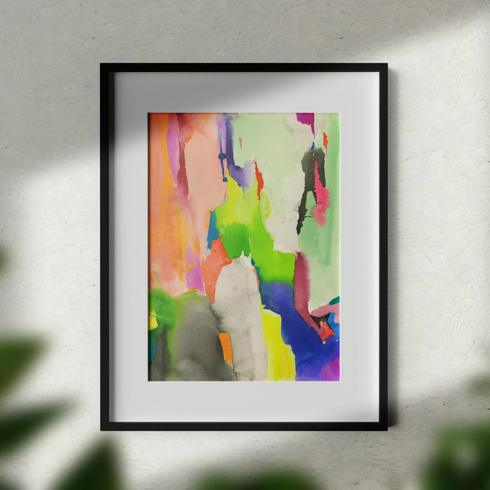 Color Cracks framed in black sits on a softly lit wall, with sunlight casting gentle shadows and greenery adding an organic touch.