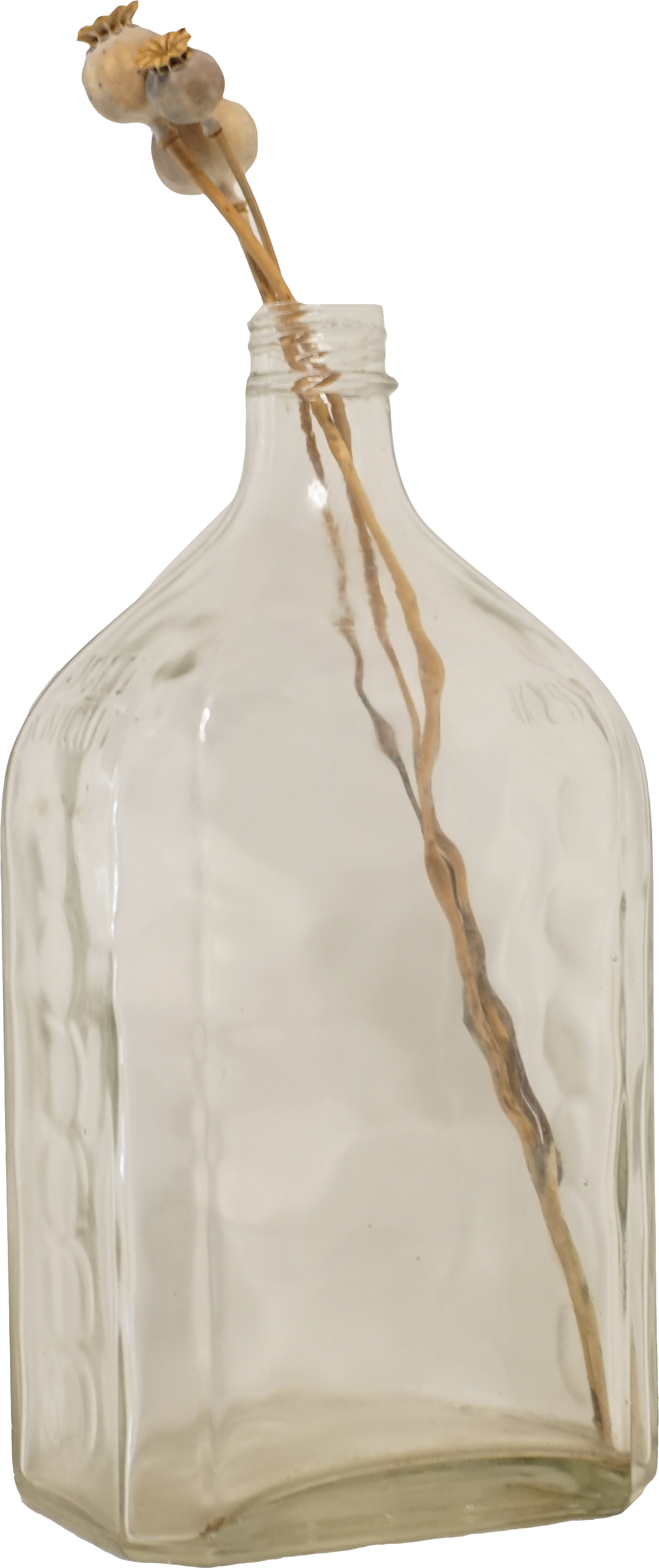 Empty glass bottle with a dried flower arrangement inside.