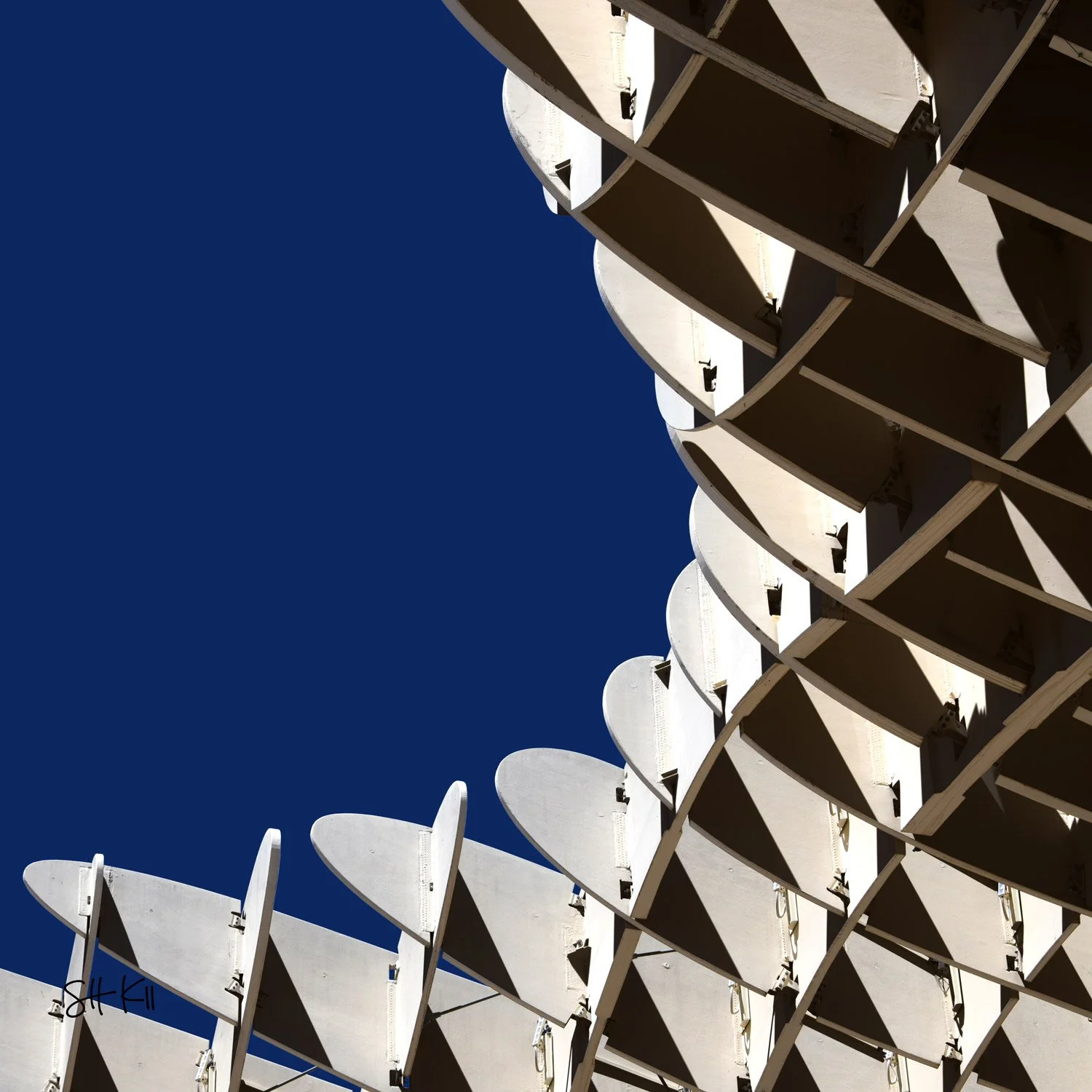 Curved lattice canopy with scalloped fins swooping against deep blue sky — Metropol Parasol Seville photograph