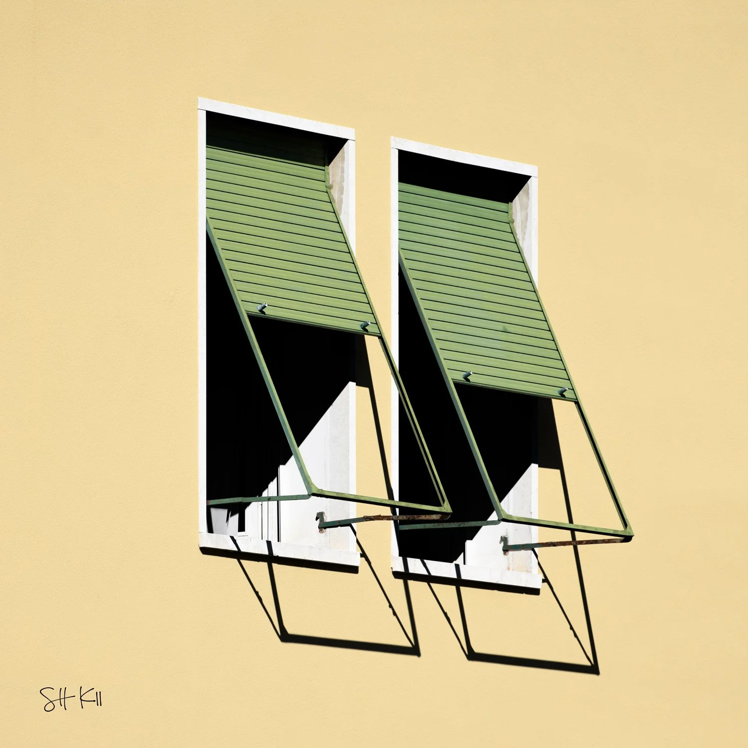 Pale yellow wall with two propped-open sage green louvered shutters on iron stays — Venice architecture photograph