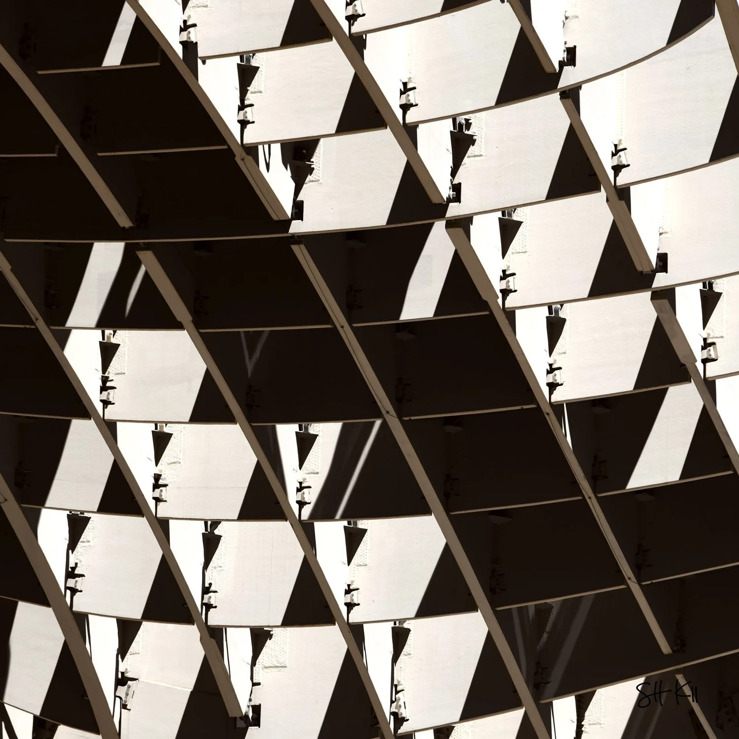 Diamond lattice pattern in warm sunlit tones with deep triangular shadows — Metropol Parasol Seville photograph