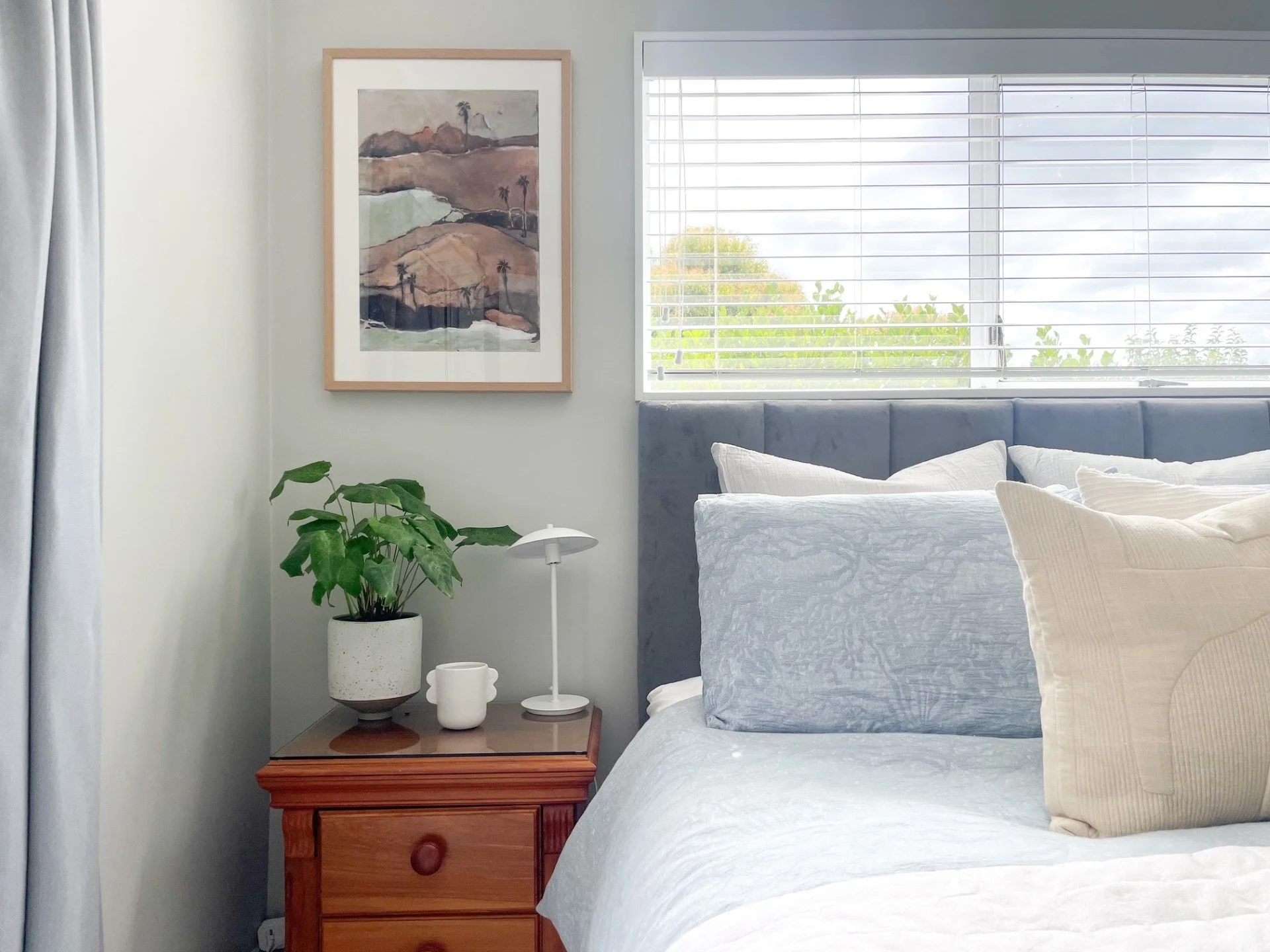 Howick bedroom refresh with modern artwork and plant by Auckland interior designer