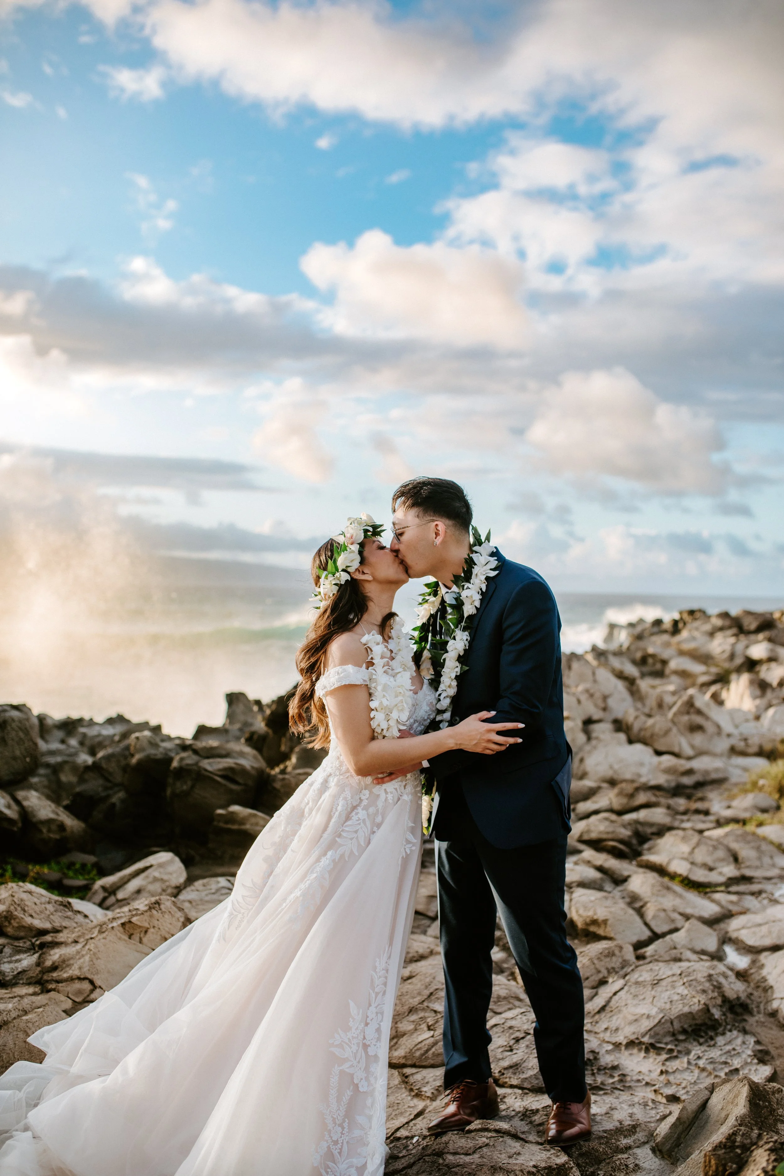 Couple stand on a cliff with the sunset in the background near Maui Pineapple Chapel