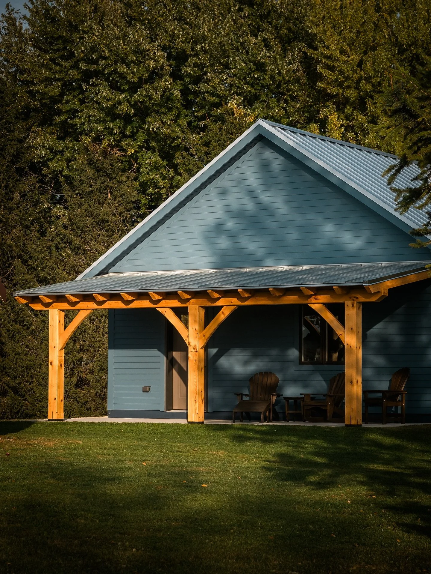 Post and beam structure with exposed timber columns and roof framing on a modern home exterior.