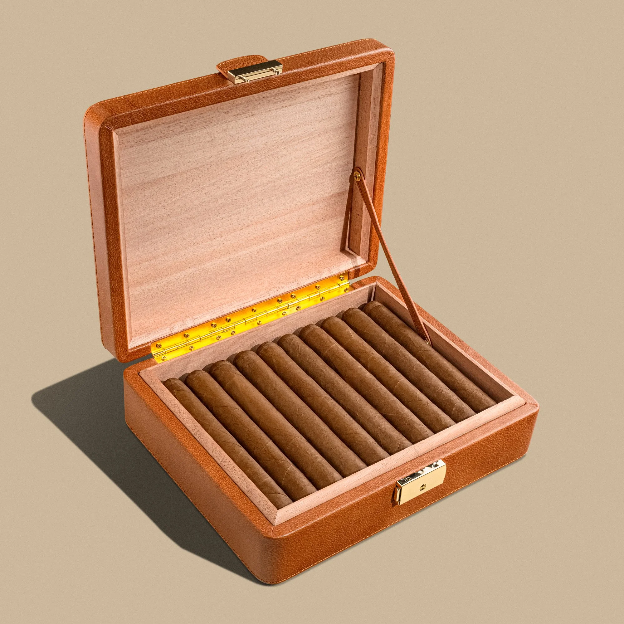 Open cigar humidor with cigars inside on a neutral background.
