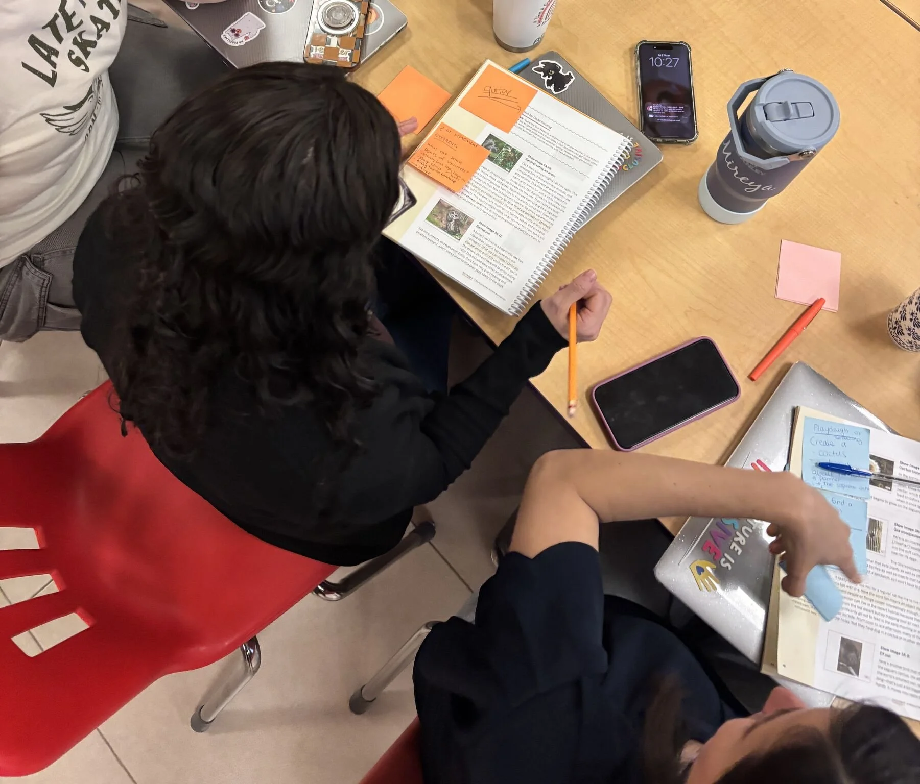 Teacher with young student in a library points to word on a page