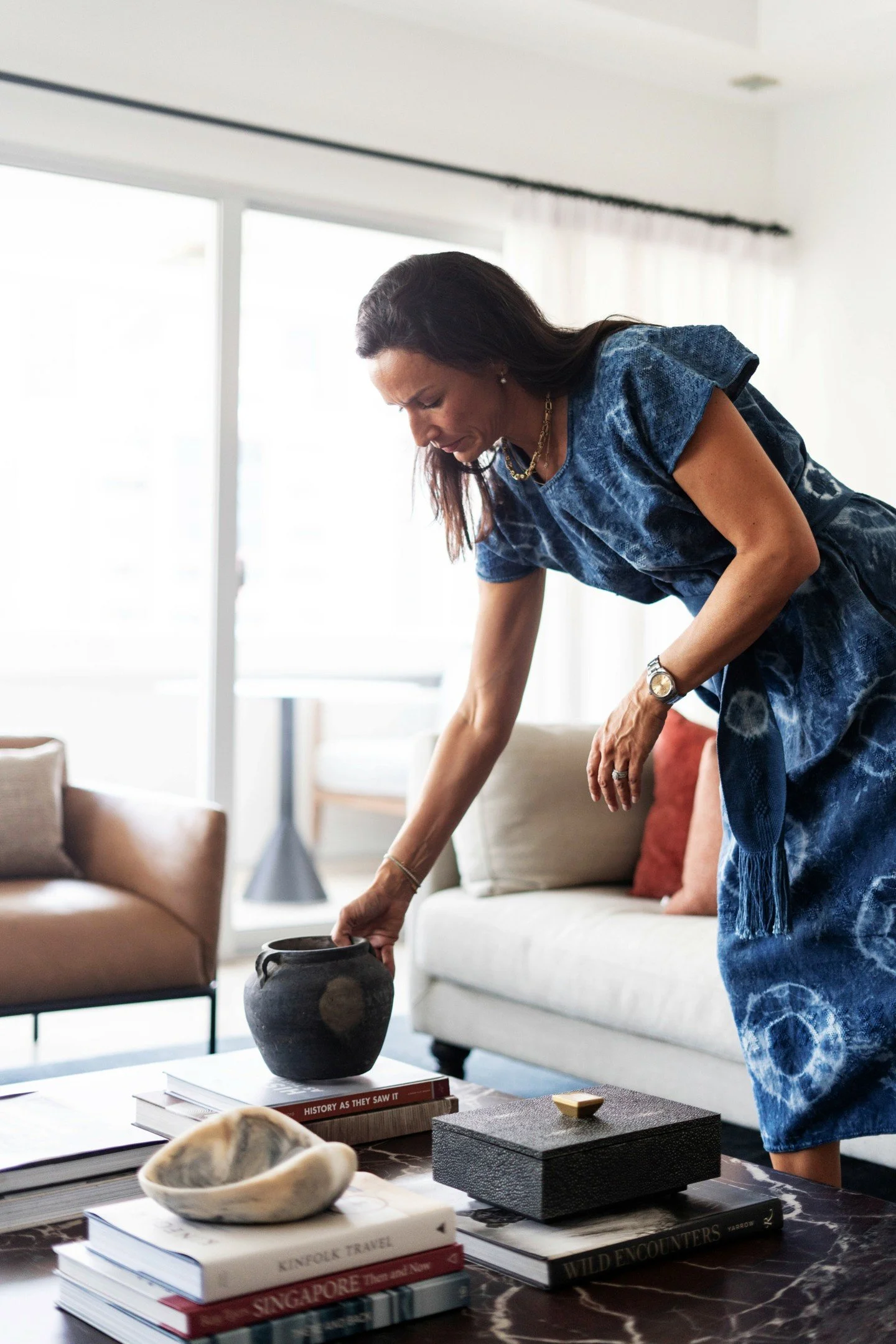 Just me, styling the coffee table at our Leonie Hill project.

It&rsquo;s easy to overthink, but the best approach is simple: curate pieces you genuinely love, layer different shapes and textures, and play with height (coffee table books are your sec