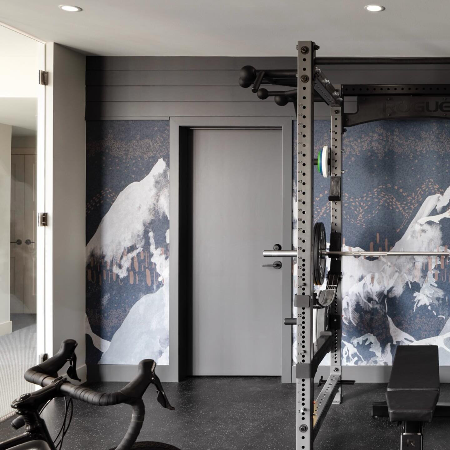 Motivation to work out is high in this bespoke home gym. A custom mural keeps the focus squarely on the reasons to put in the work. We worked with this family to craft a space that flows with the adjacent media area and fits all the key equipment and