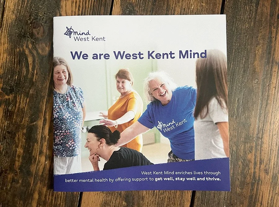 Square brochure with a photograph of a group of smiling women, engaged in physical play. The document is titled 'We are West Kent Mind'.