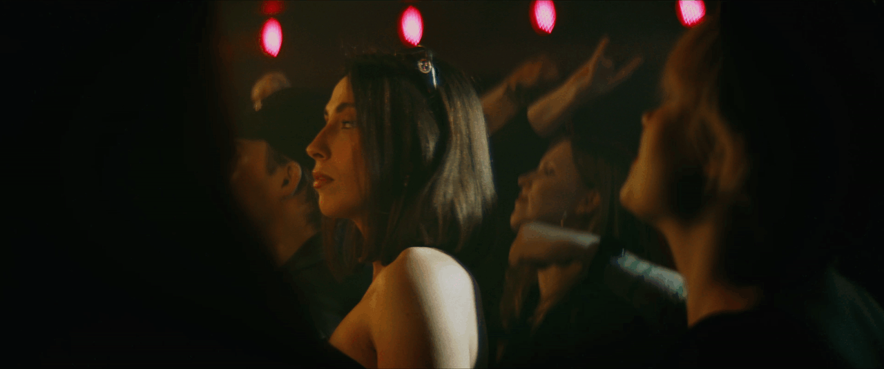 Women at a nightclub with red lights, dancing and socializing.