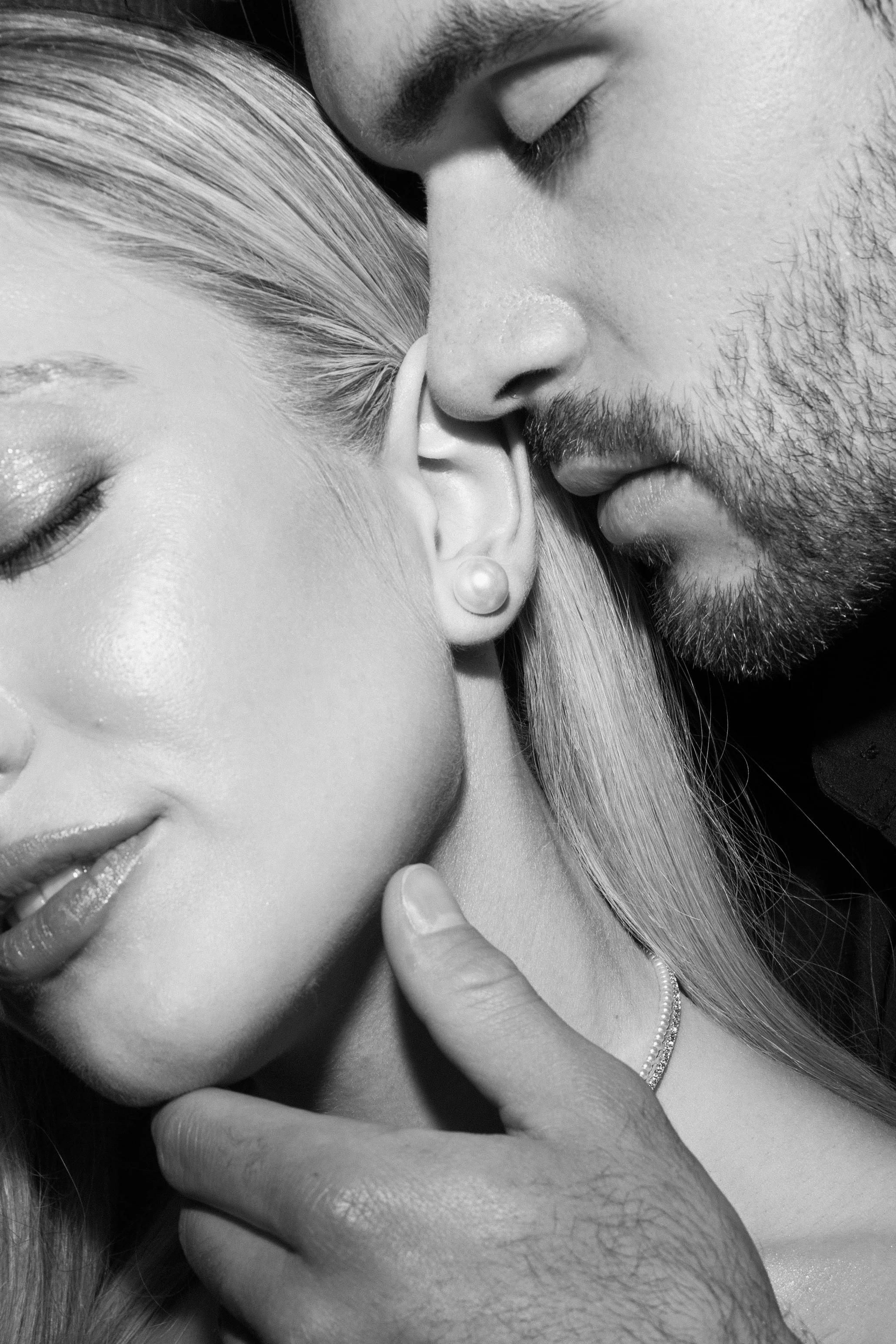 Nahaufnahme eines Paares, das sich liebevoll berührt, mit geschlossenen Augen, in Schwarz-Weiß-Optik.