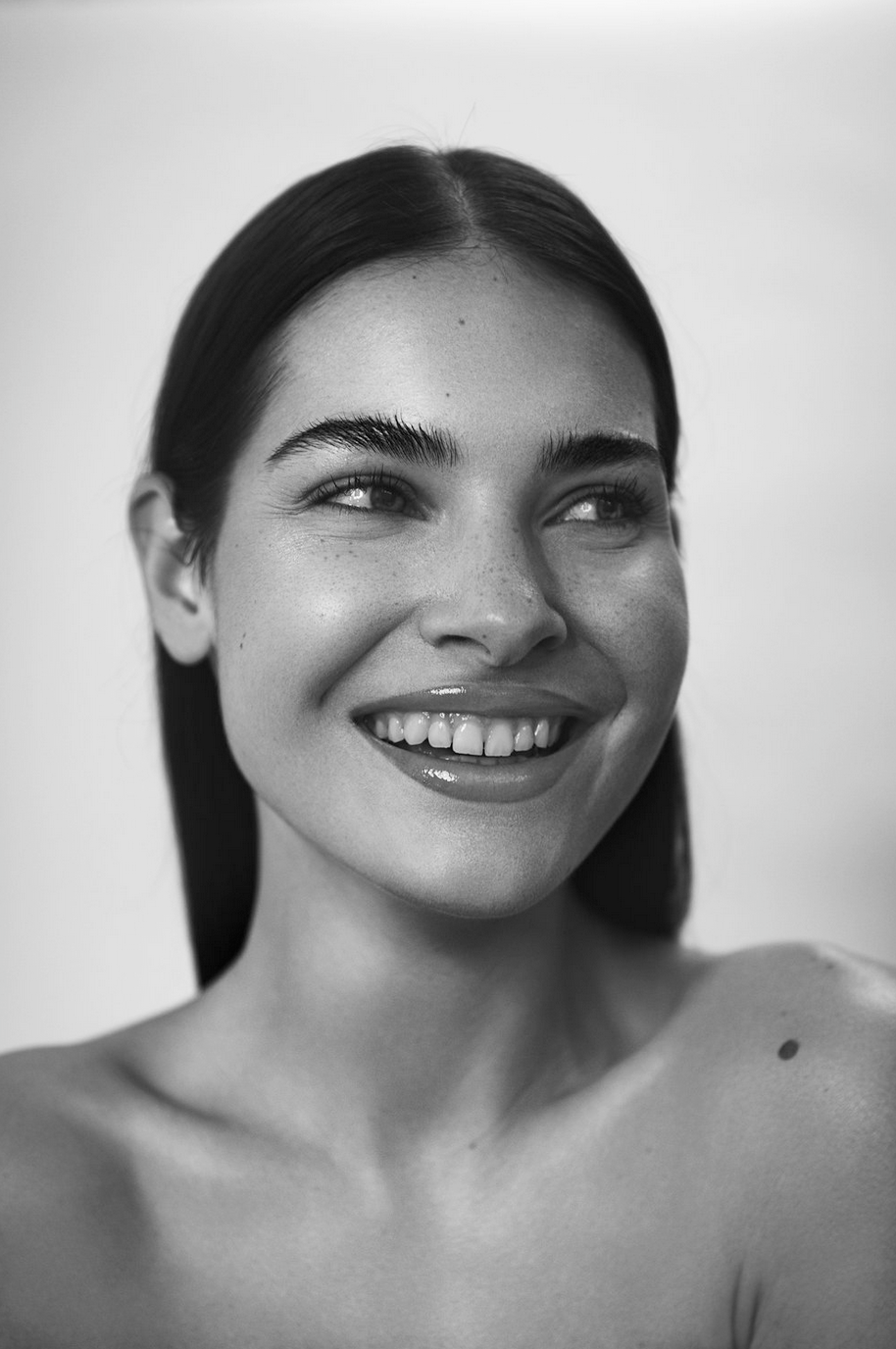 Porträt eines lachenden jungen Frauengesichts in Schwarz-Weiß