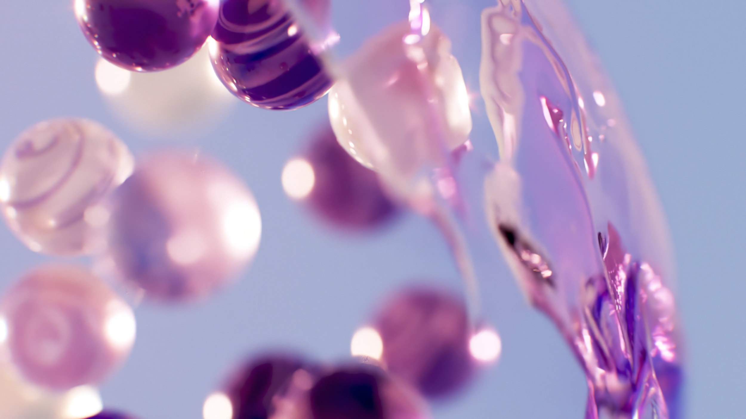 Abstract image with pink and purple glass-like spheres and a swirling liquid effect.