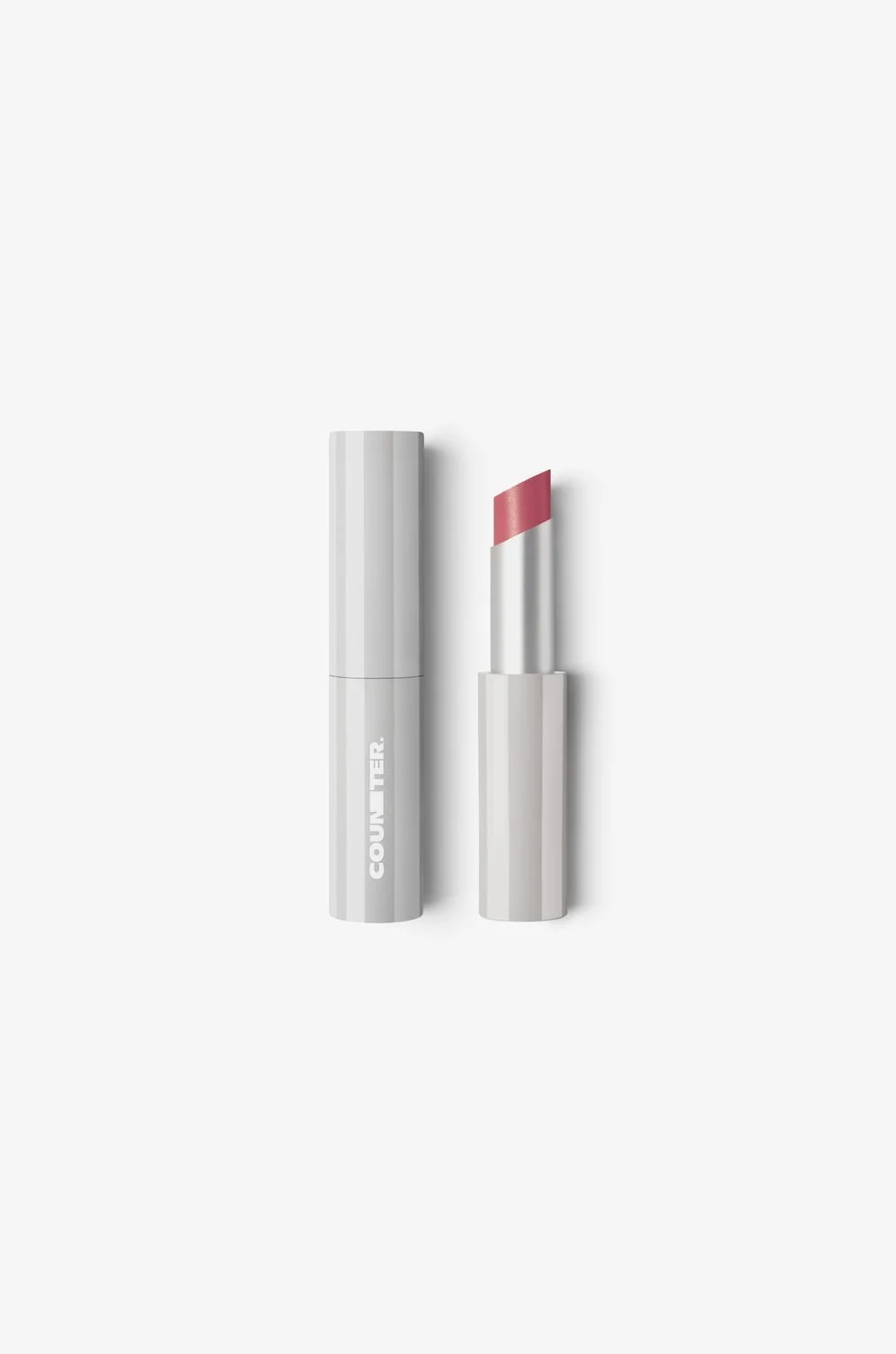 A white lip balm tube with the lip balm partially extended showing pink lipstick inside, placed on a white background.