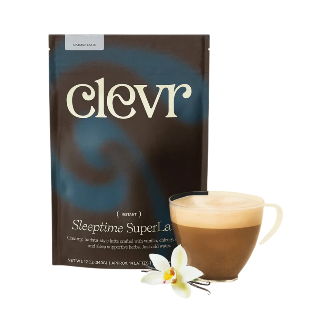 A package of Clever Sleptime SuperLatte herbal latte mix with a prepared latte in a glass mug, accompanied by a white orchid flower.