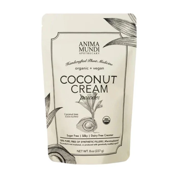 A beige pouch of Anima Mundi Apothecary Organic Vegan Coconut Cream Powder with black text and illustrations of coconut halves and leaves.