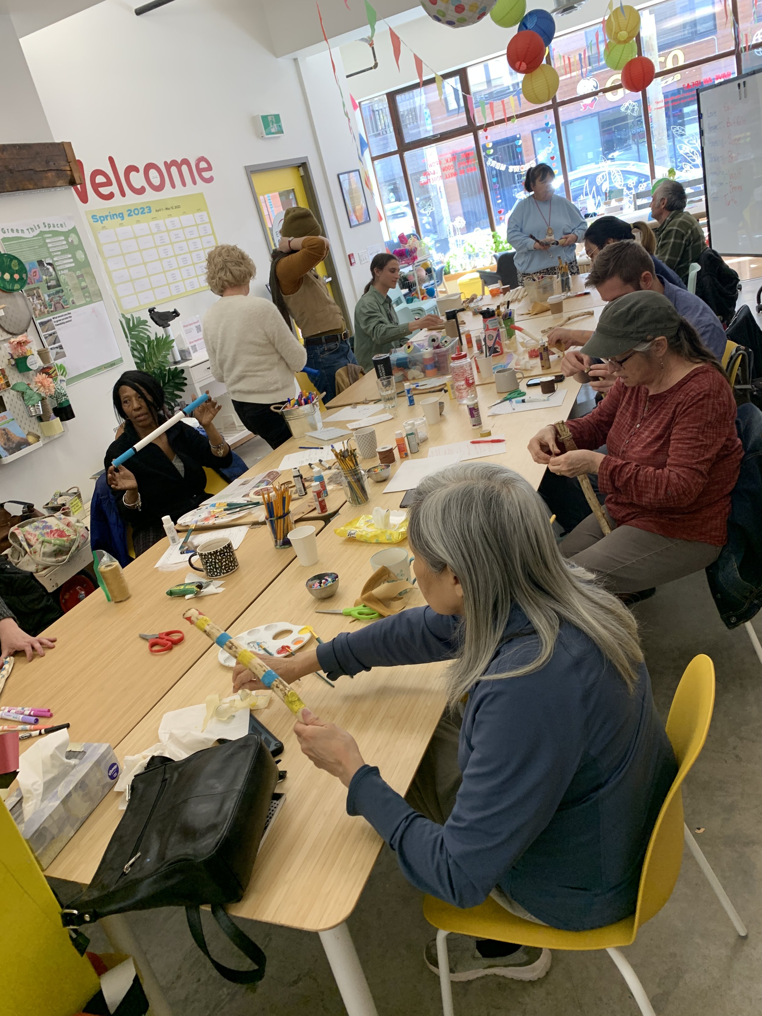 Neighbours learn about and make talking sticks in a session hosted by Elder Deb.