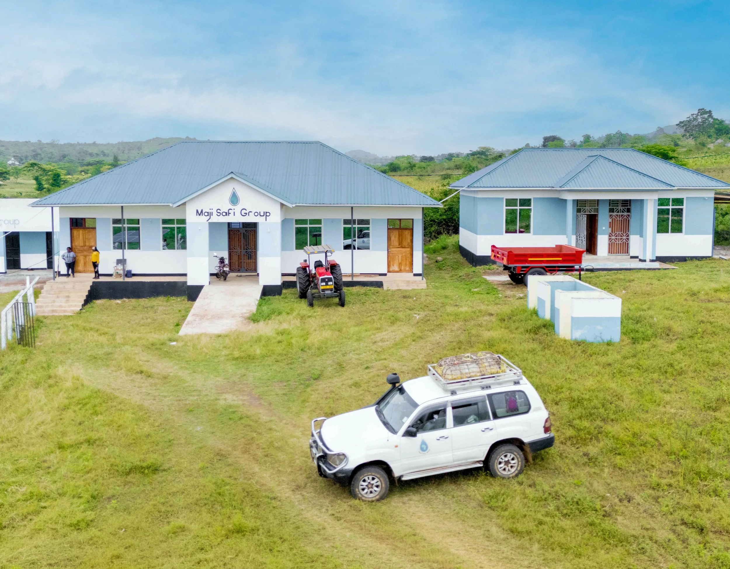 View of WASH Hub No. 1 with a group of buildings and white vehicle.