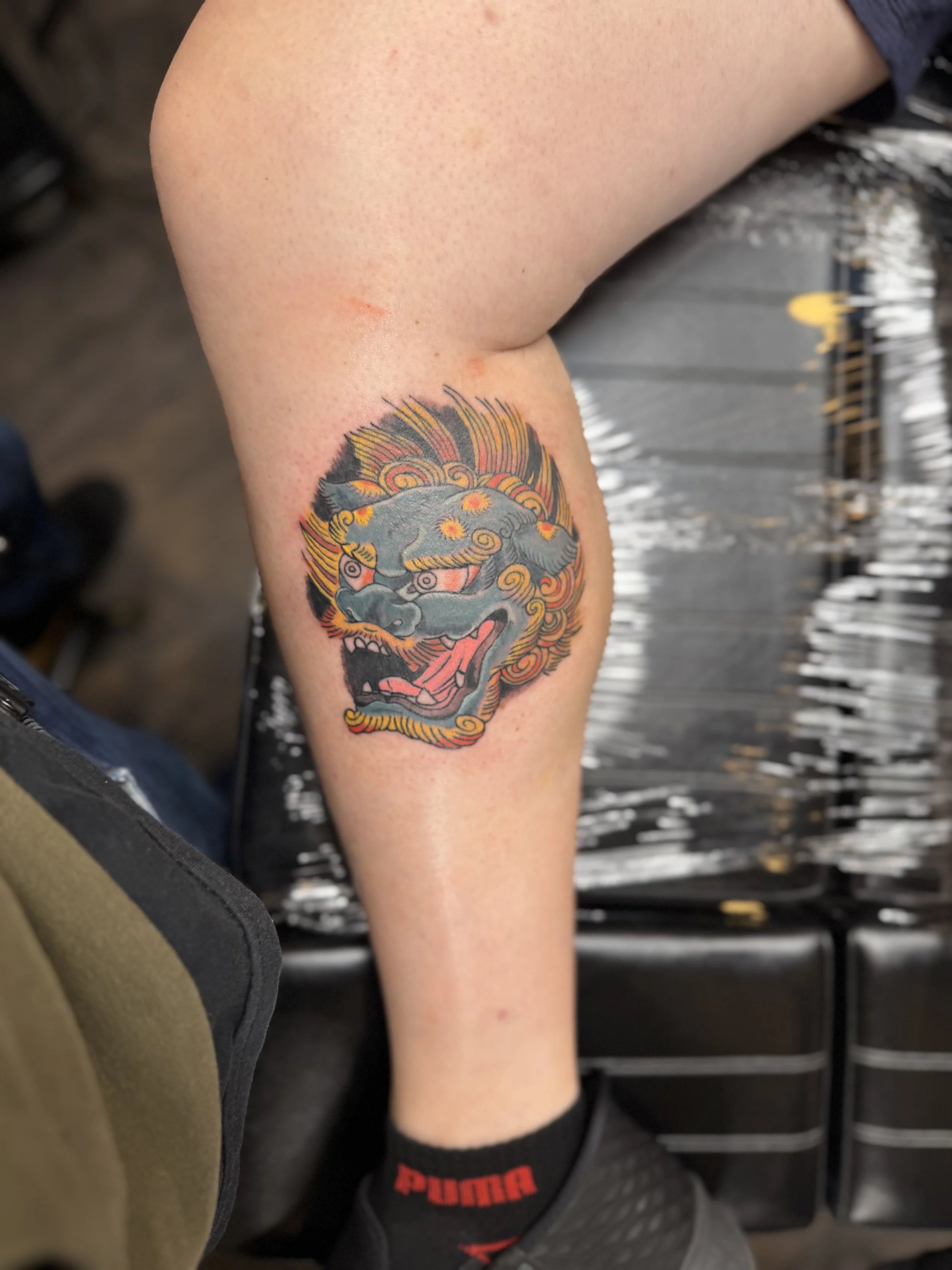Colorful traditional Asian-style dragon tattoo on person's calf.