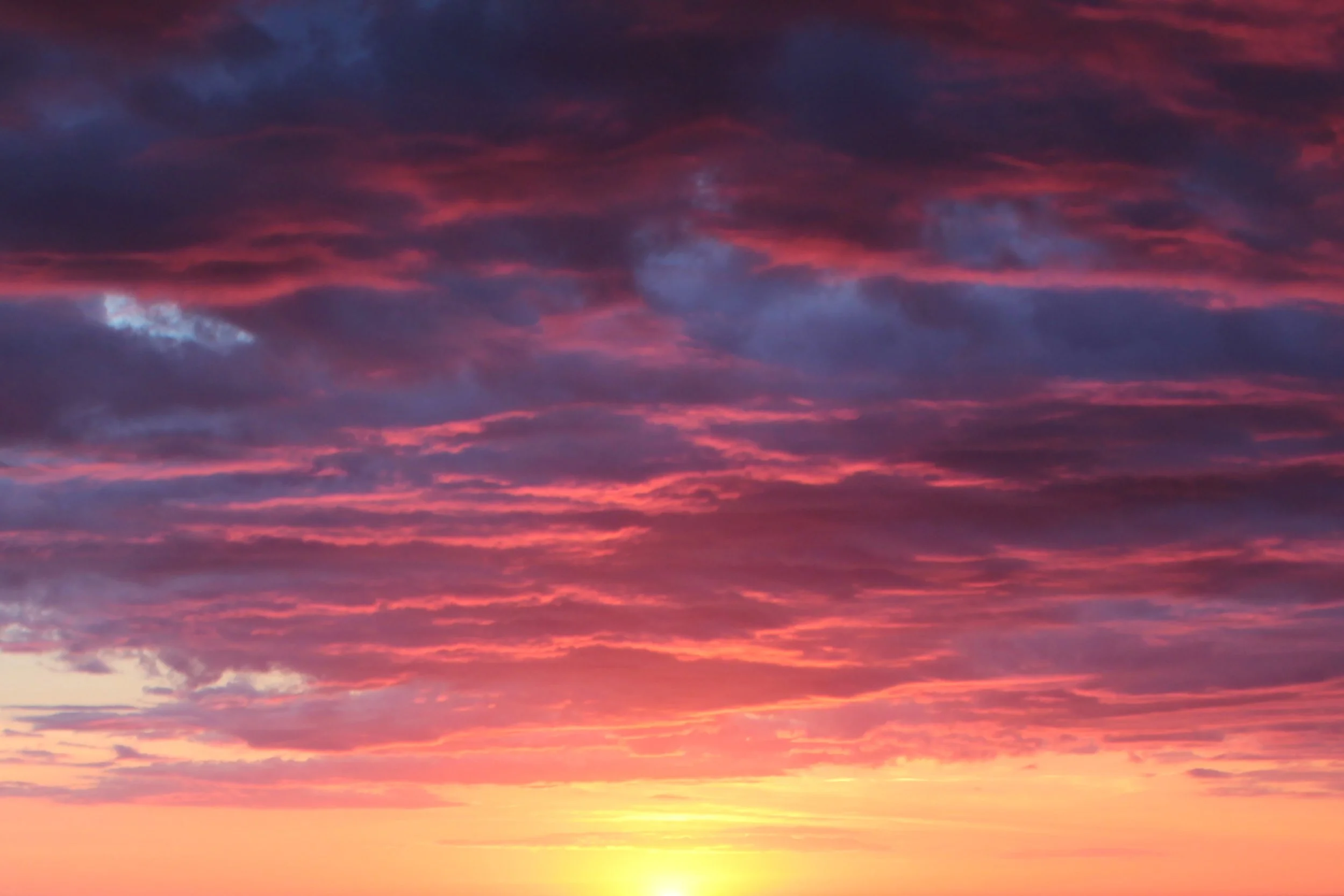 A colorful sunset with pink, purple, and blue clouds in the sky.