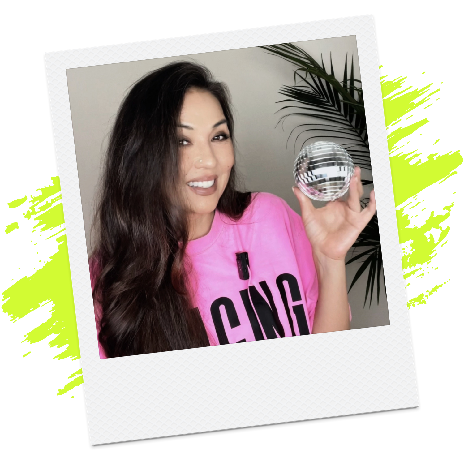 Melodee smiling in a pink shirt while holding a silver disco ball