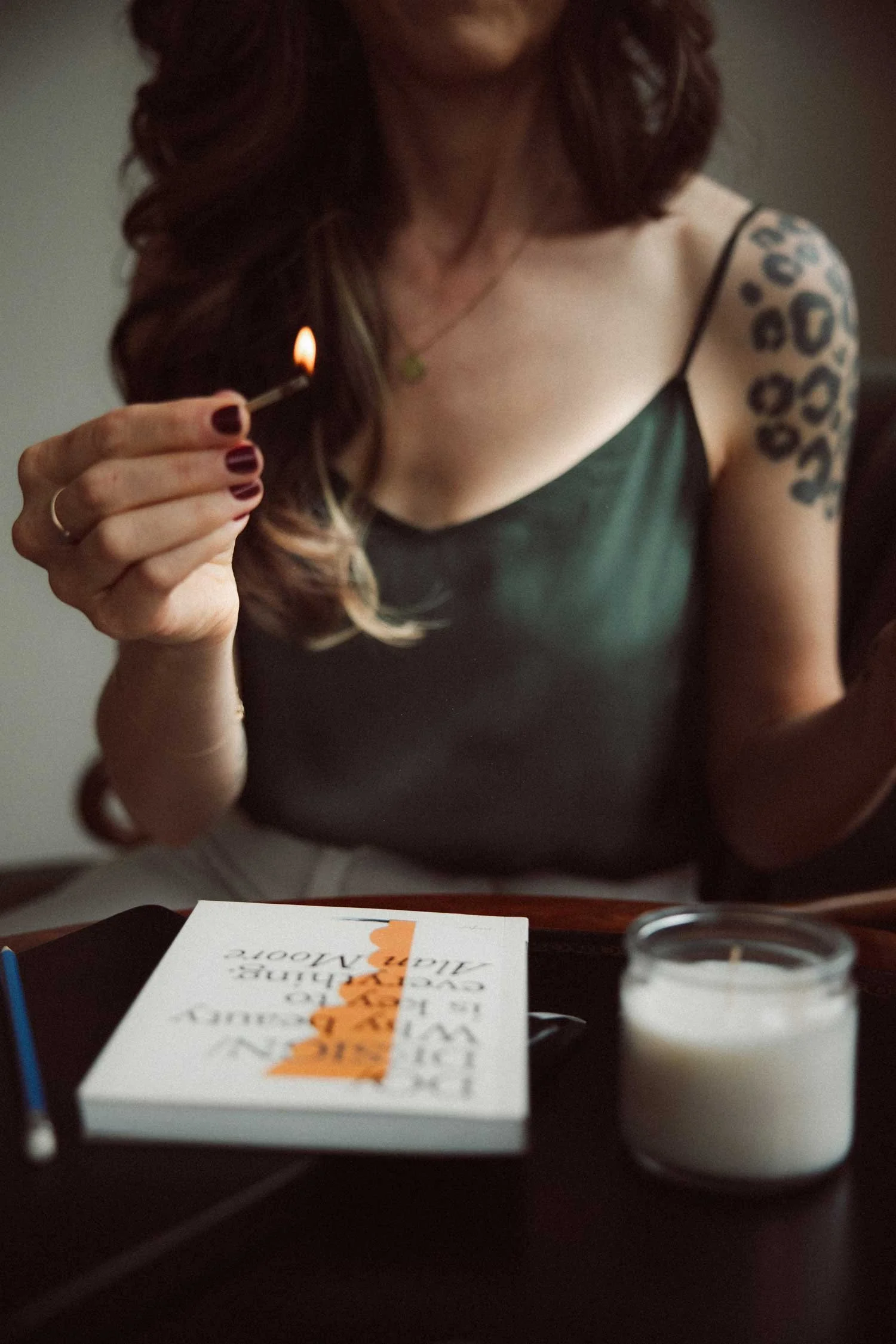 Miranda, founder of Moonstone, holds a lit match over a white candle
