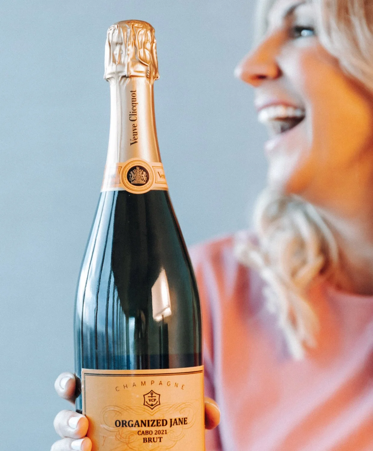 Jane Stoller of Organized Jane holding a custom Organized Jane branded Veuve Clicquot champagne bottle from Cabo 2021