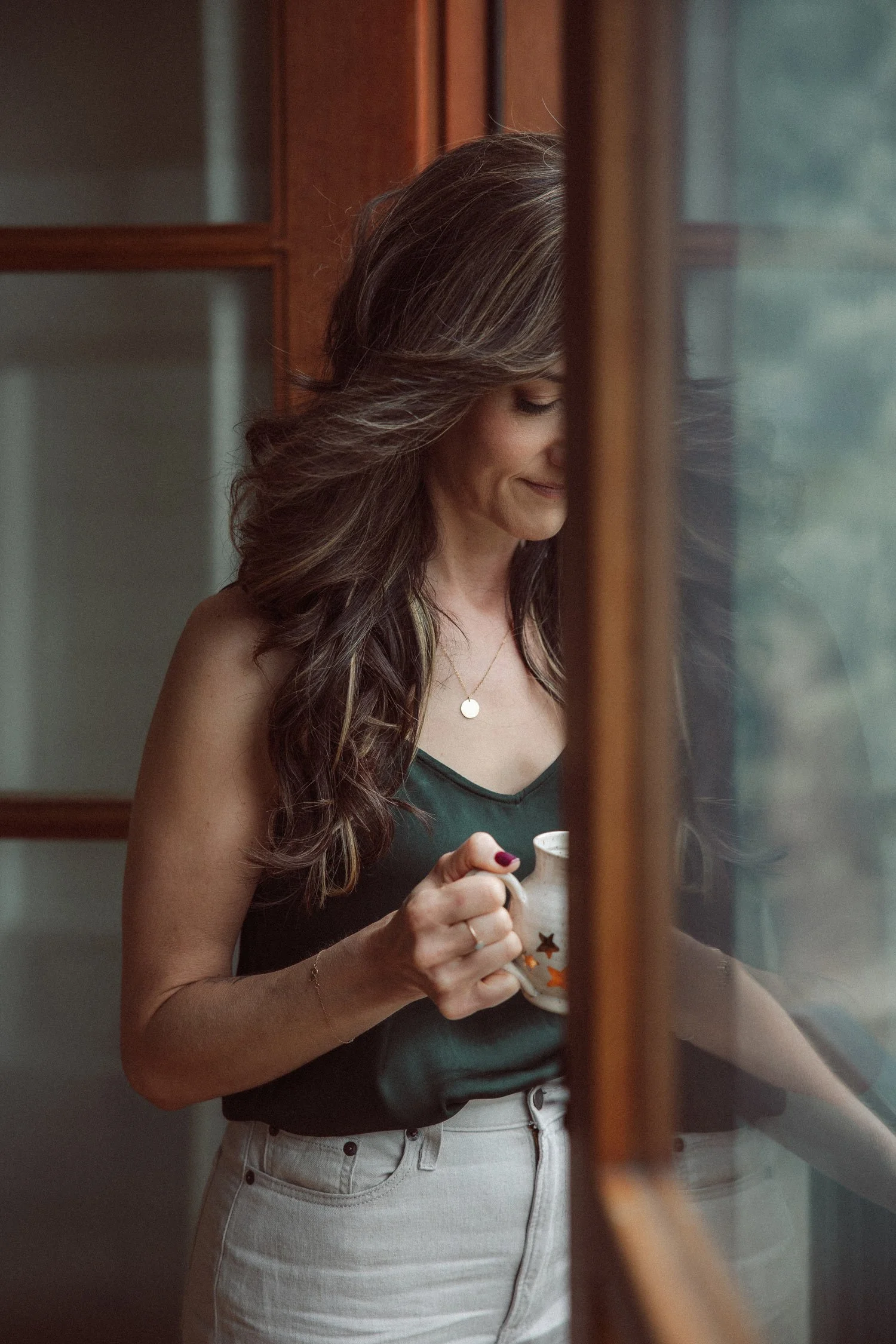 Miranda of Moonstone Creative holding a star mug by an open window