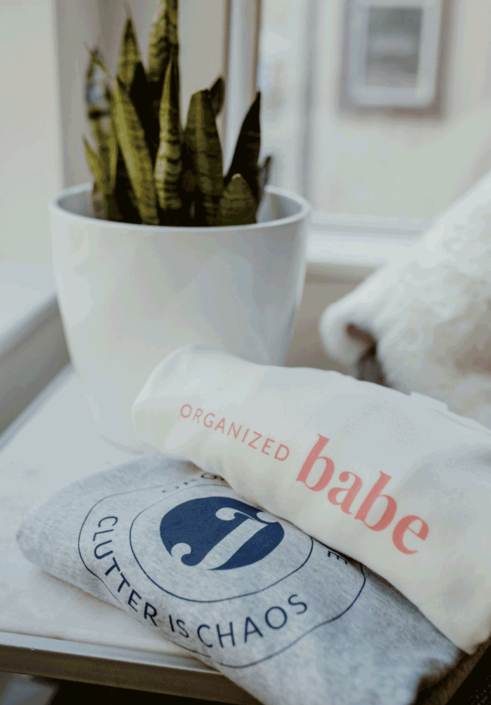 Organized Jane branded apparel and merch including champagne glasses, napkins, and Organized Babe and Clutter is Chaos crewnecks designed by Moonstone Creative