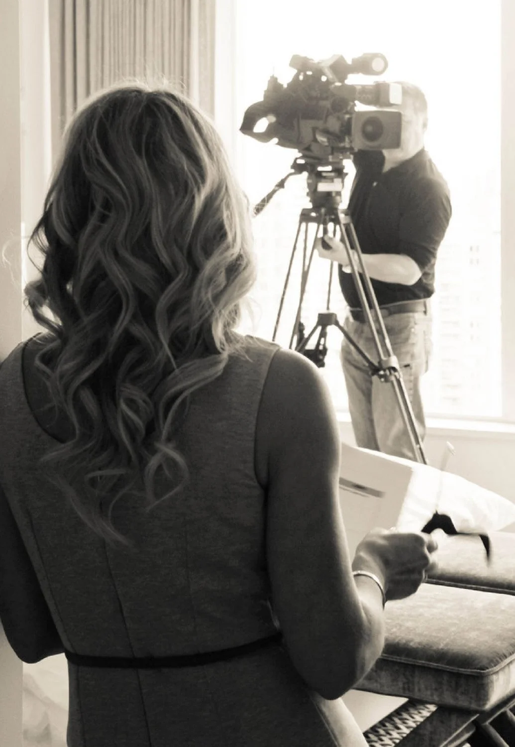 Jane Stoller of Organized Jane photographed from behind during a television filming with a camera operator in black and white