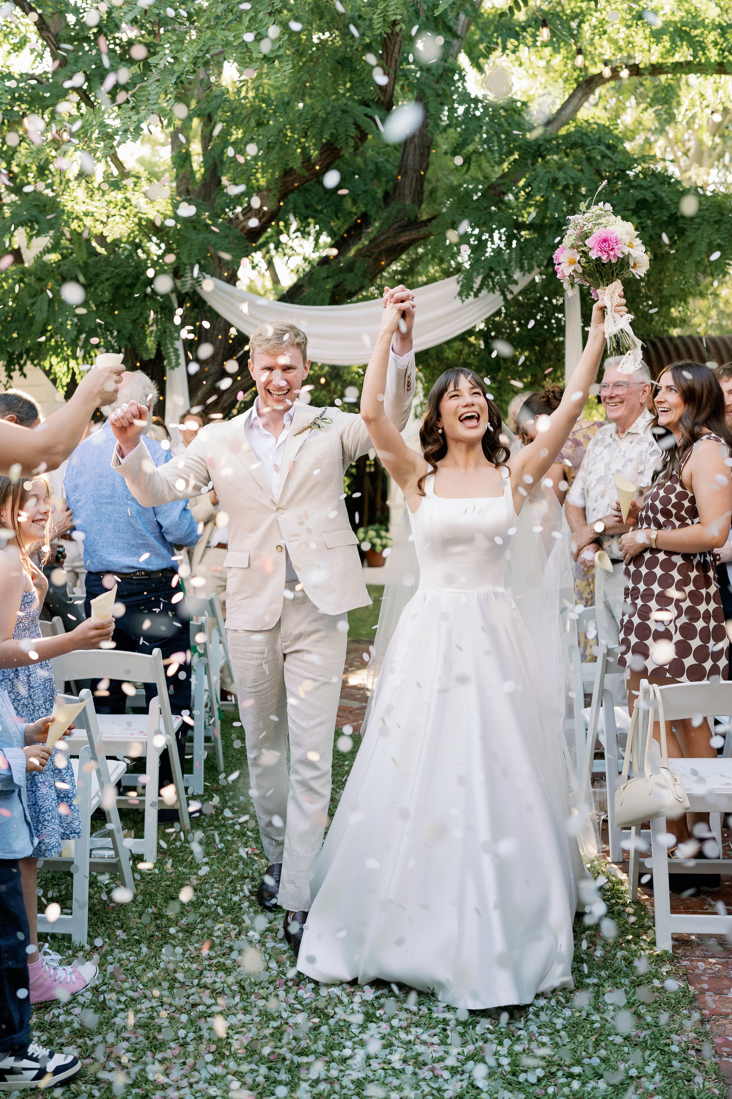 couple's confetti exit after their relaxed backyard wedding ceremony in East Fremantle. Captured my top perth wedding photographer, Natalie Jane, with a candid, documentary and fun approach, editing in a bright and colourful style.