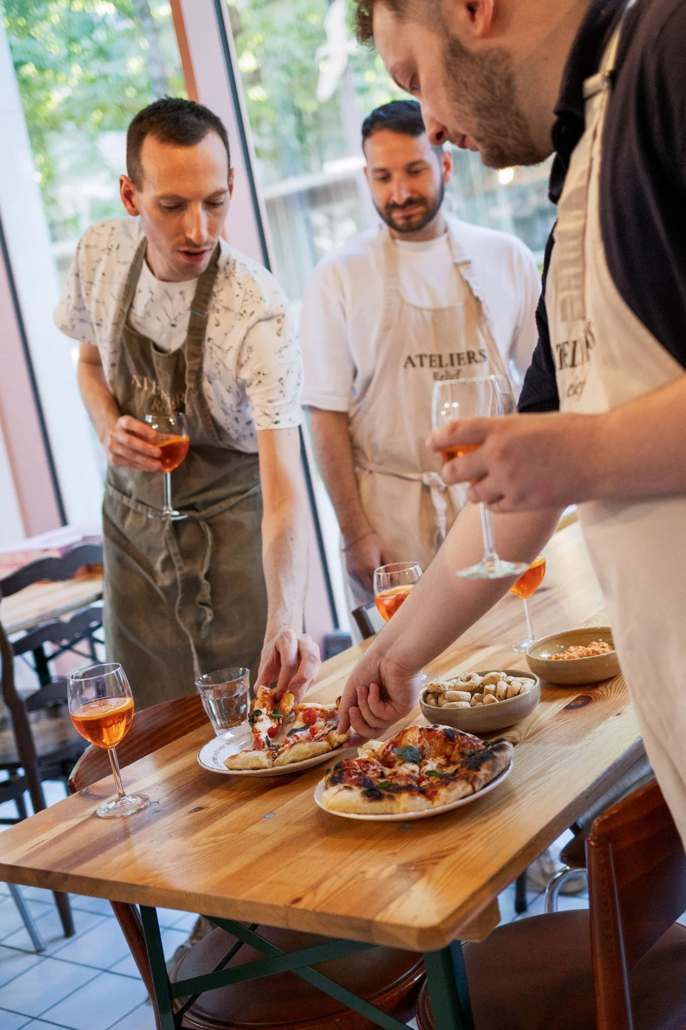Les convives partagent et dégustent un aperitivo italien fait maison au début de l'atelier pizza.