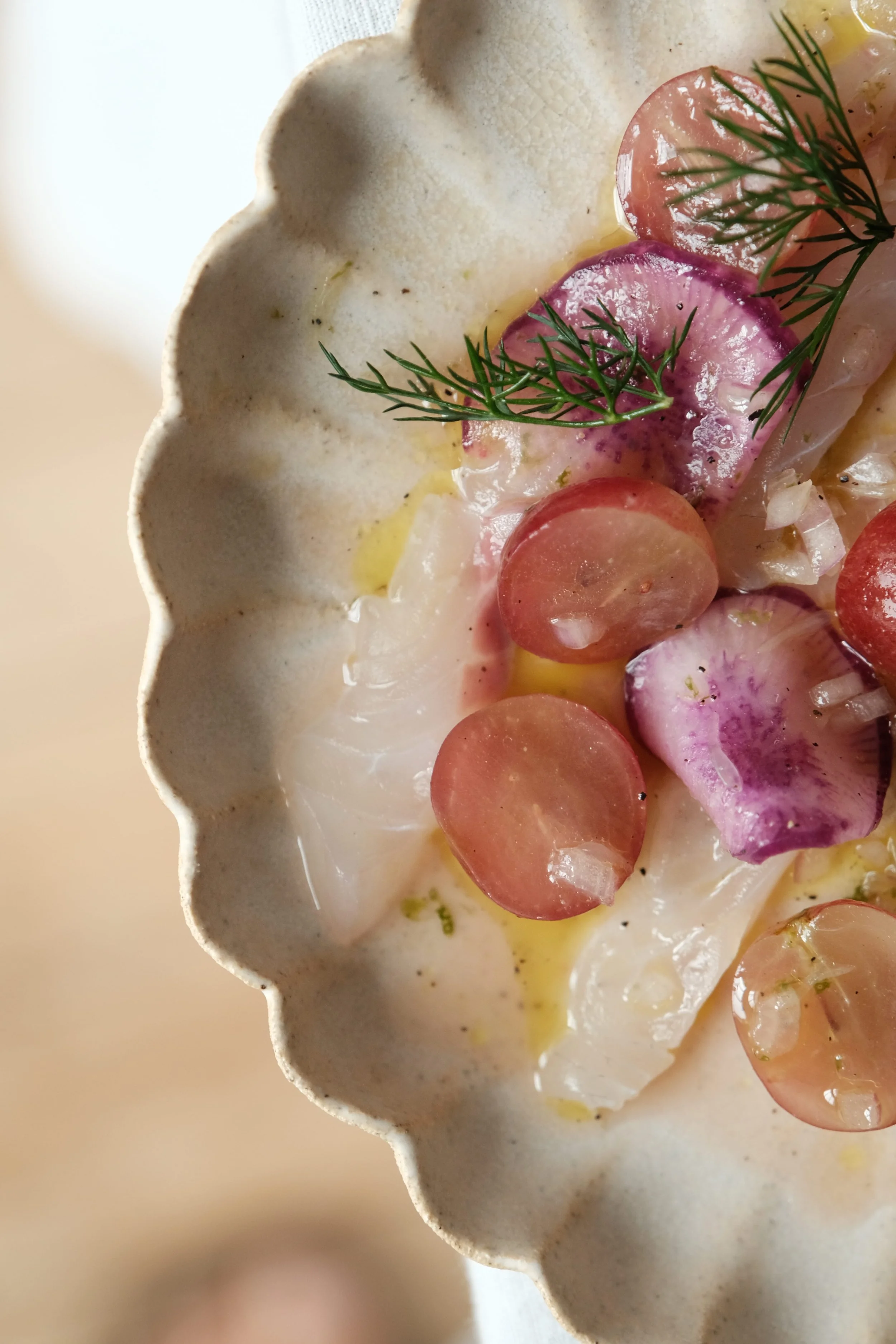 Détail de la découpe et du dressage de notre recette de crudo de maigre ultra-frais aux notes japonaises (shiso et umami).