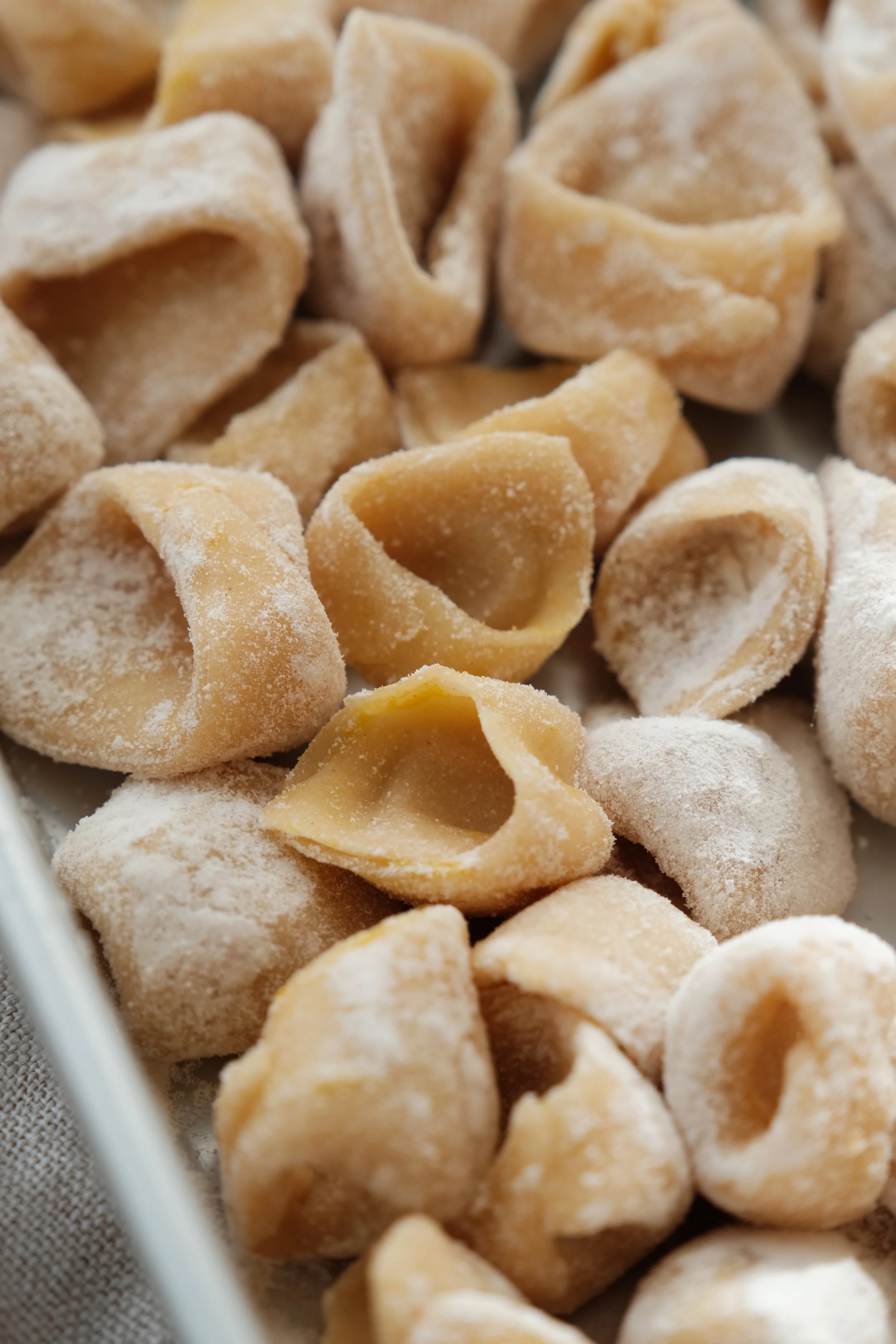 Confection de pâtes fraîches faites maison à quatre mains pendant un atelier culinaire avec un chef privé.