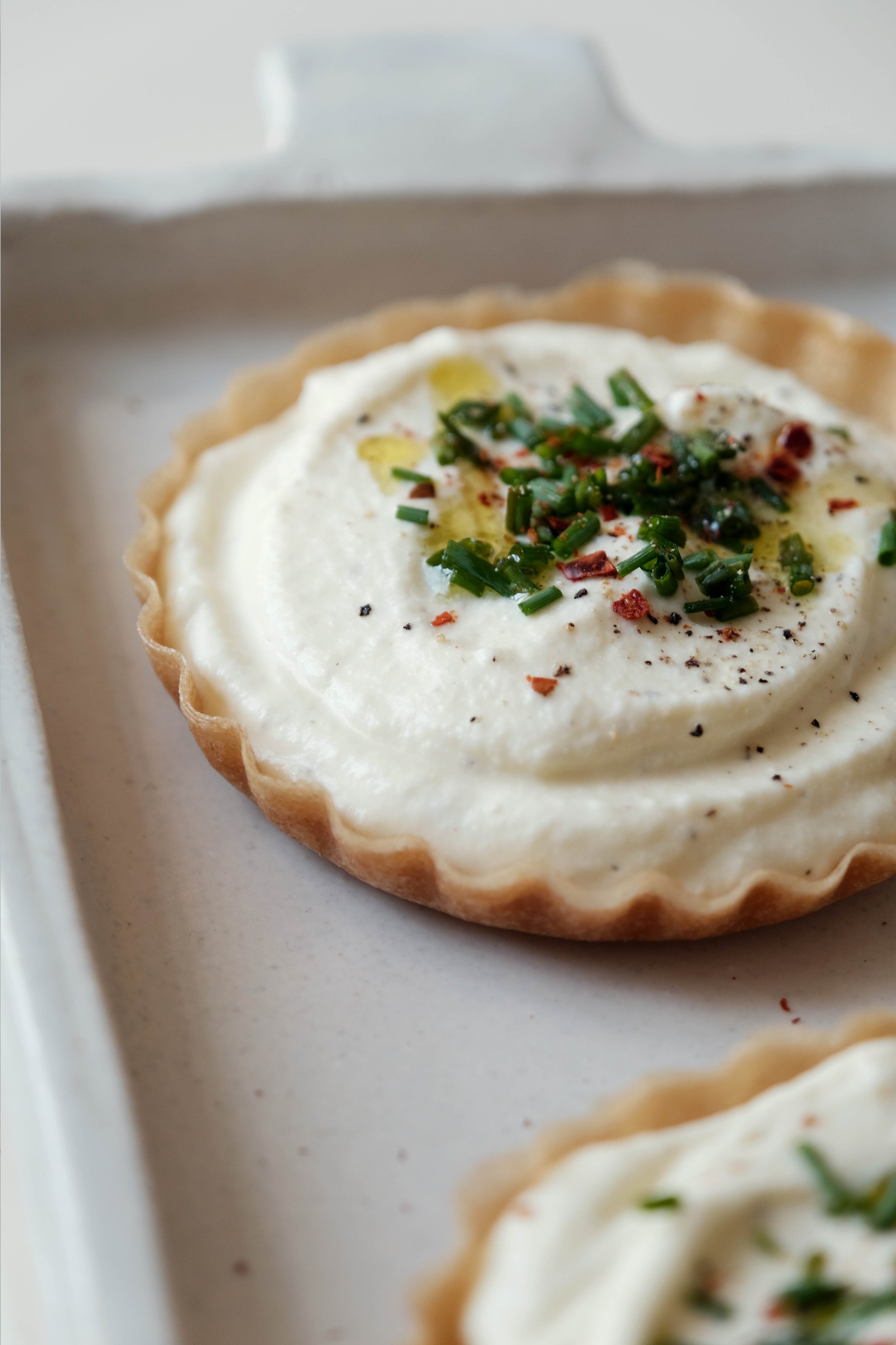 Préparation d'une délicieuse tartelette à la ricotta lors d'un cours de cuisine en couple à domicile.