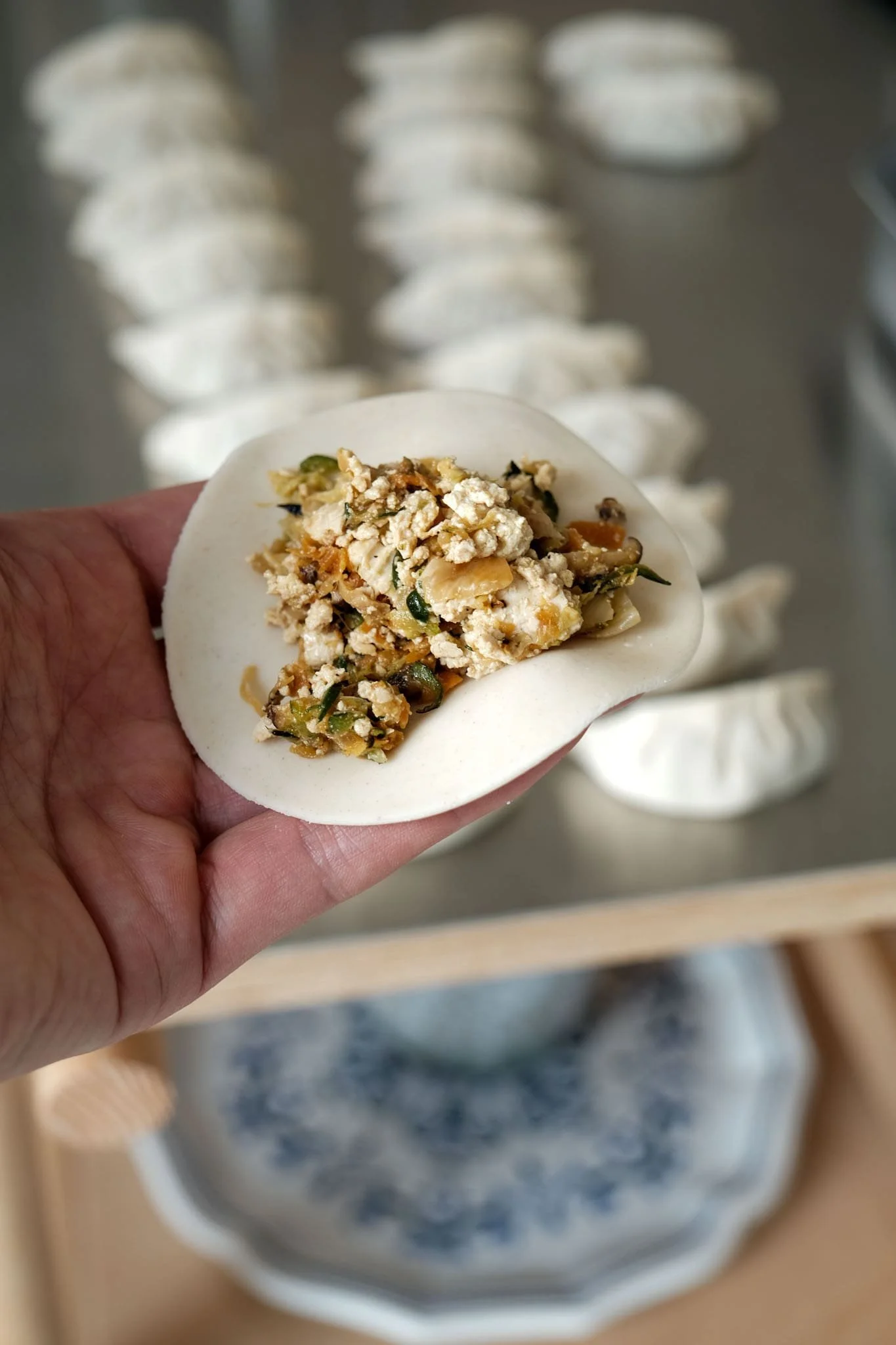 Gros plan sur le pliage des gyozas pendant un cours de cuisine participatif animé par un chef Ateliers Relief.