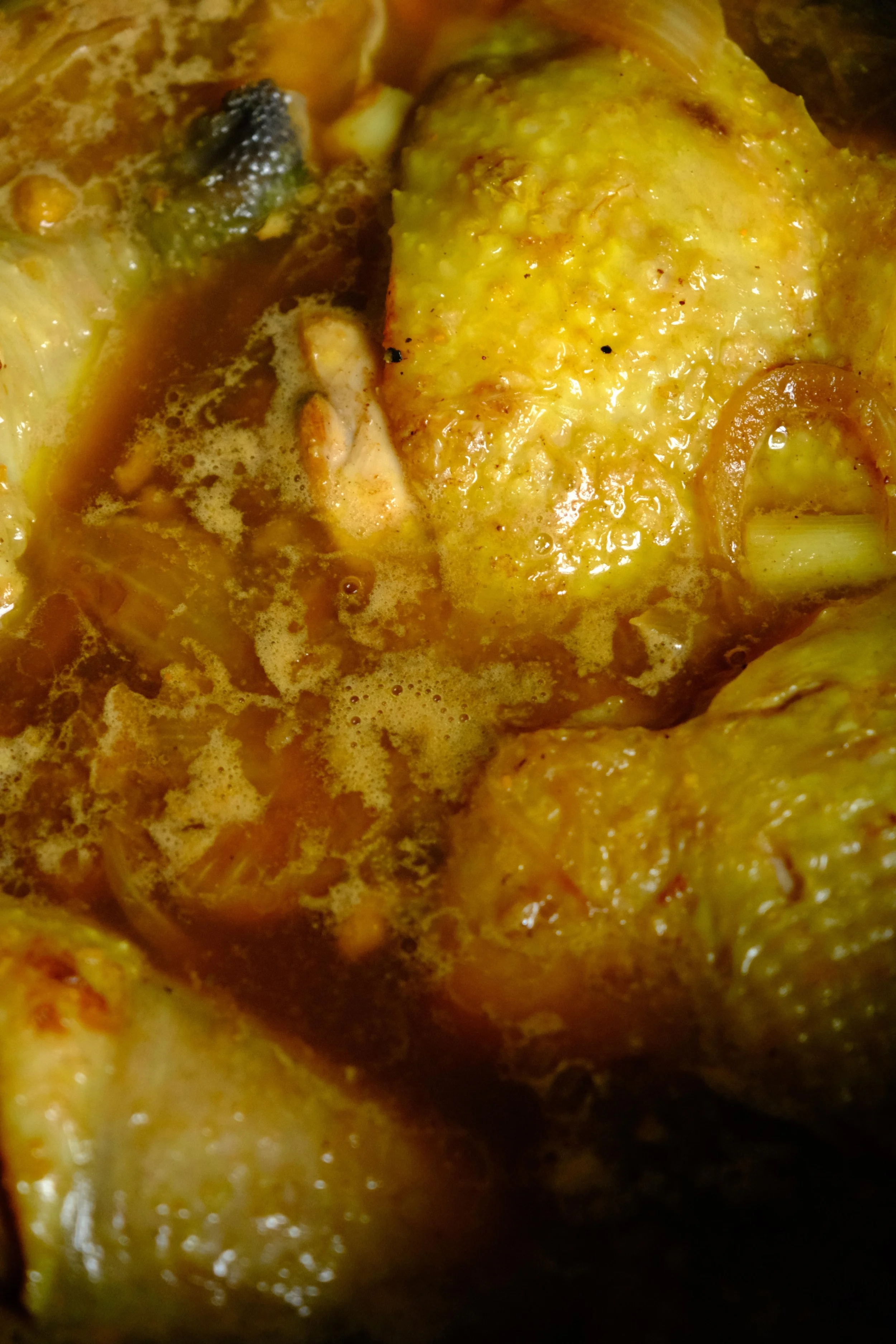 Des cuisses de poulet en train de mijoter pour préparer un tajine avec des kakis