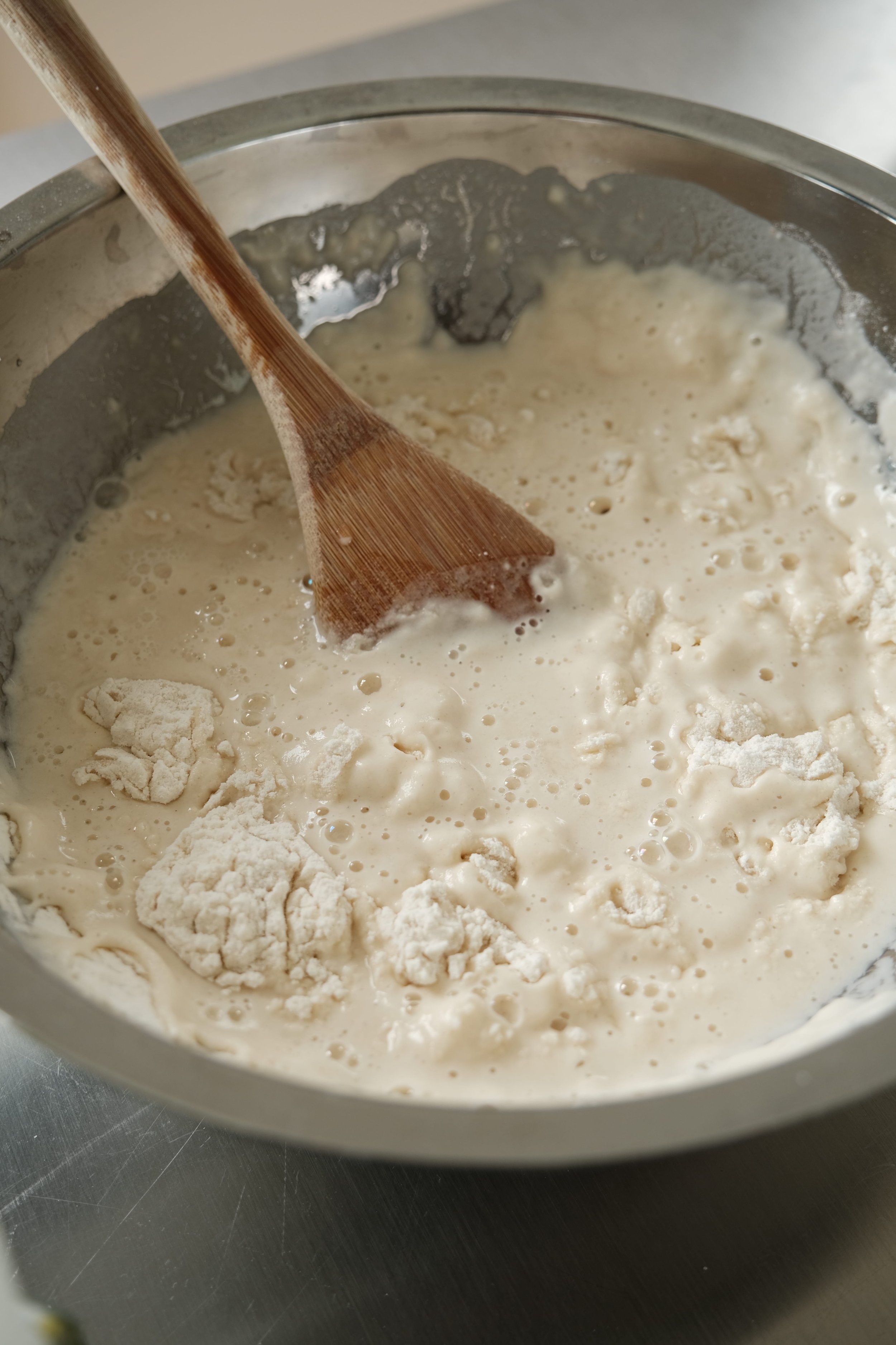 Mélange de la farine, de l'eau et de la levure pour la préparation de la pâte pendant le cours de pizza à Nantes.