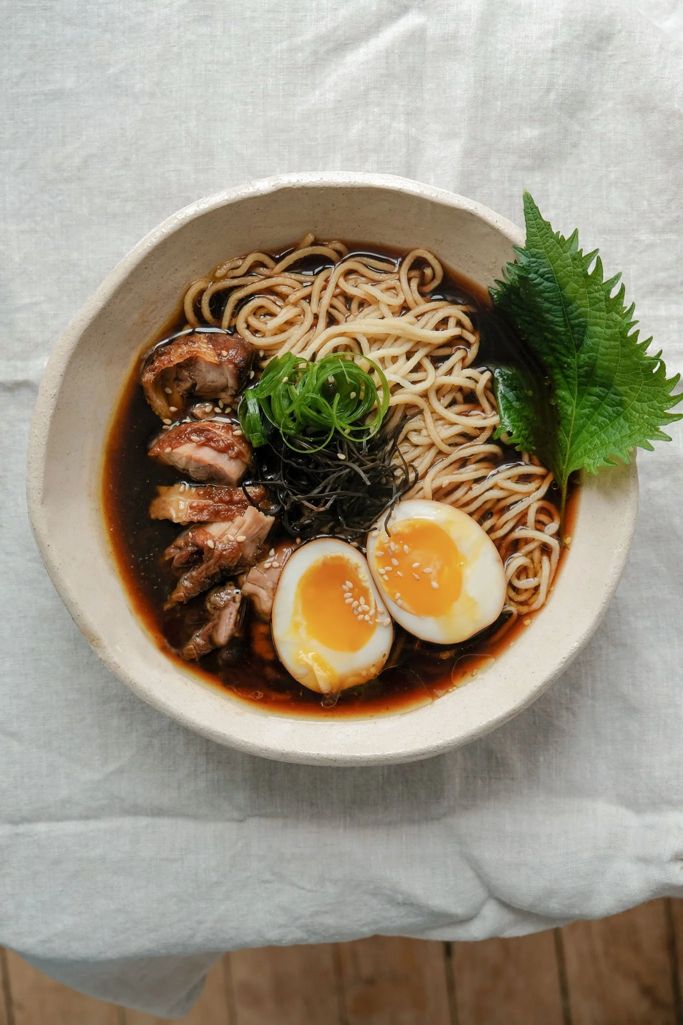 Dressage d'un bol de ramen japonais fumant avec ses nouilles et son bouillon lors d'un cours de cuisine à Nantes.