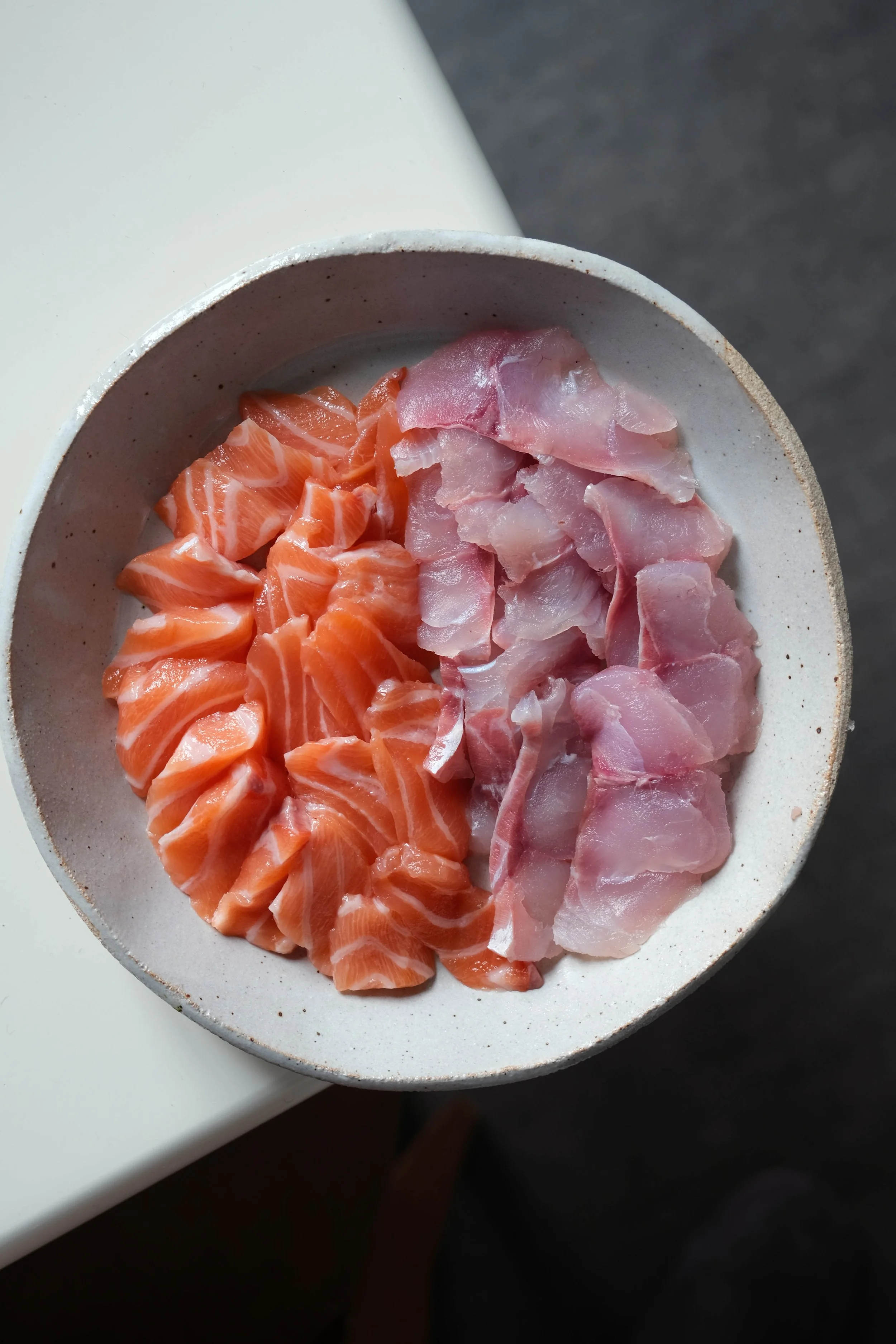 De la daurade et du saumon frais découpés en sashimi. Les morceaux seront utilisés pour préparer des temaris sushis