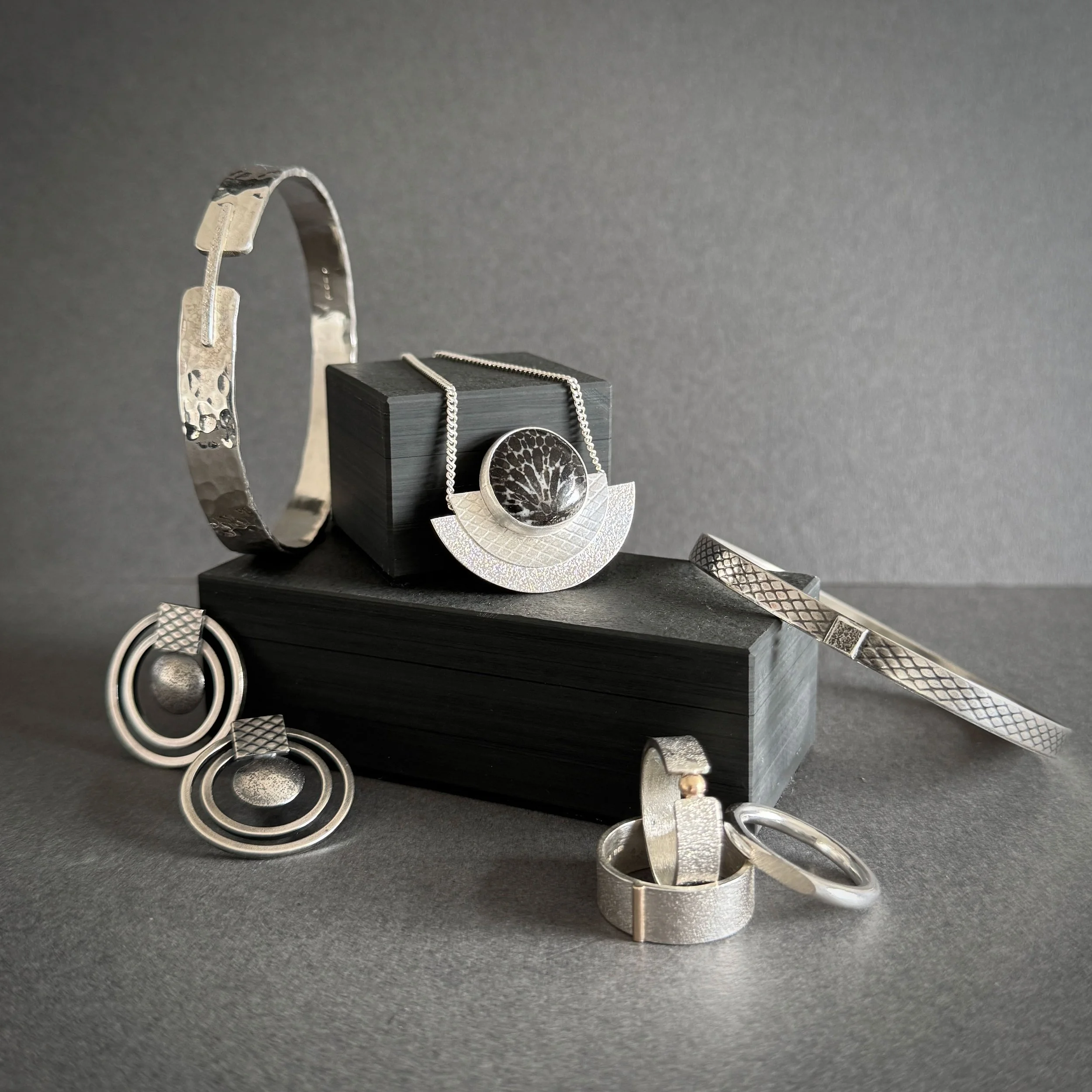 Silver and gold jewellery arranged on slate blocks