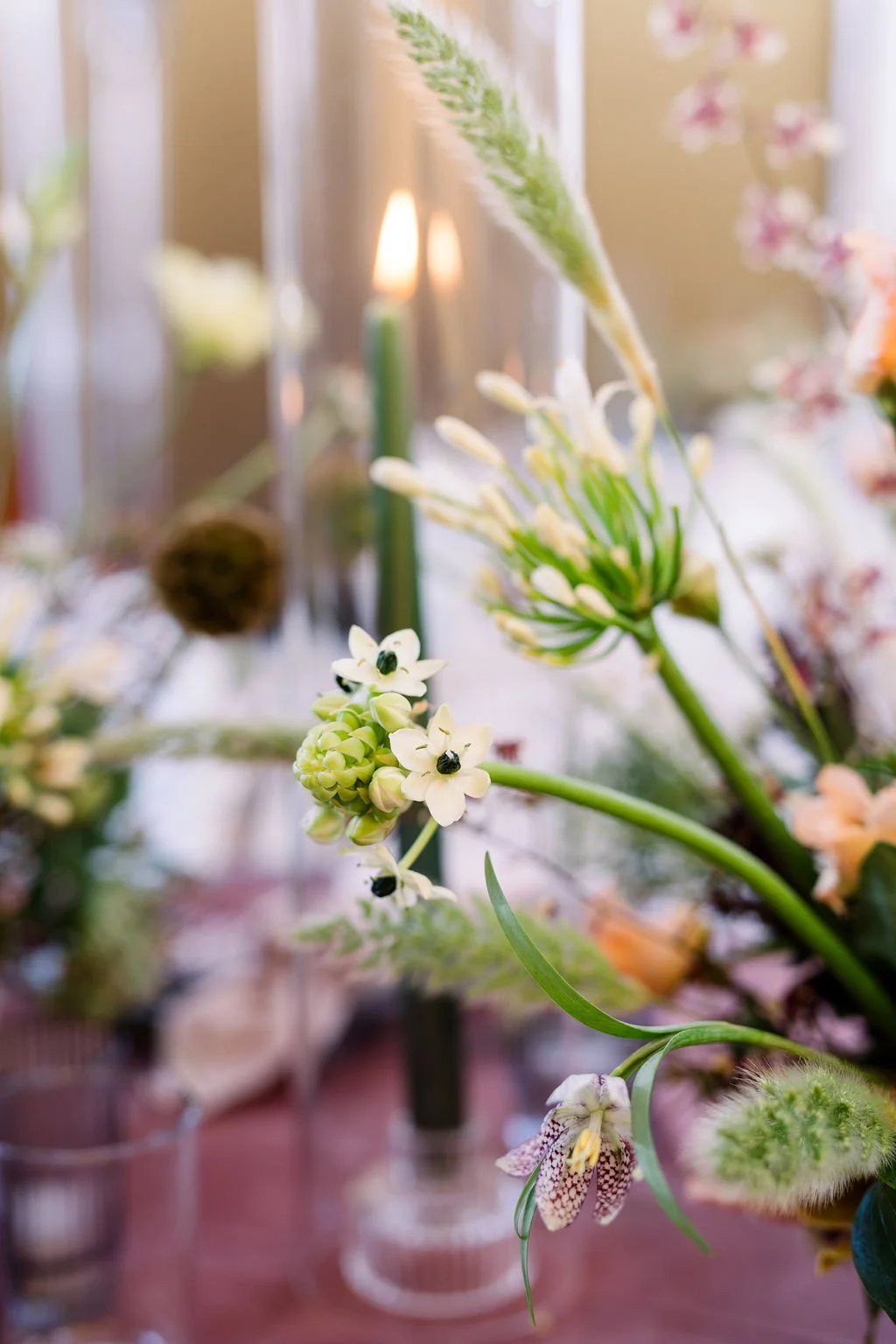  Detailed image of black and white florals in a centerpiece with candlelight. 
