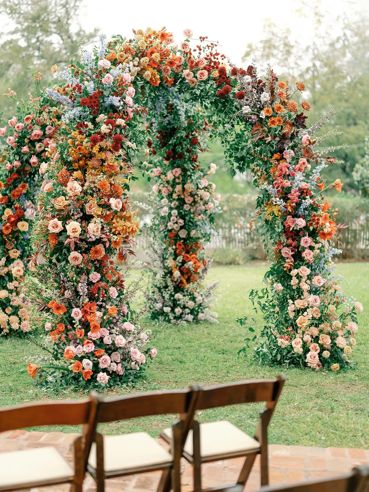  A chuppah adorned with. lush fall wedding flowers in autumn inspired colors. 