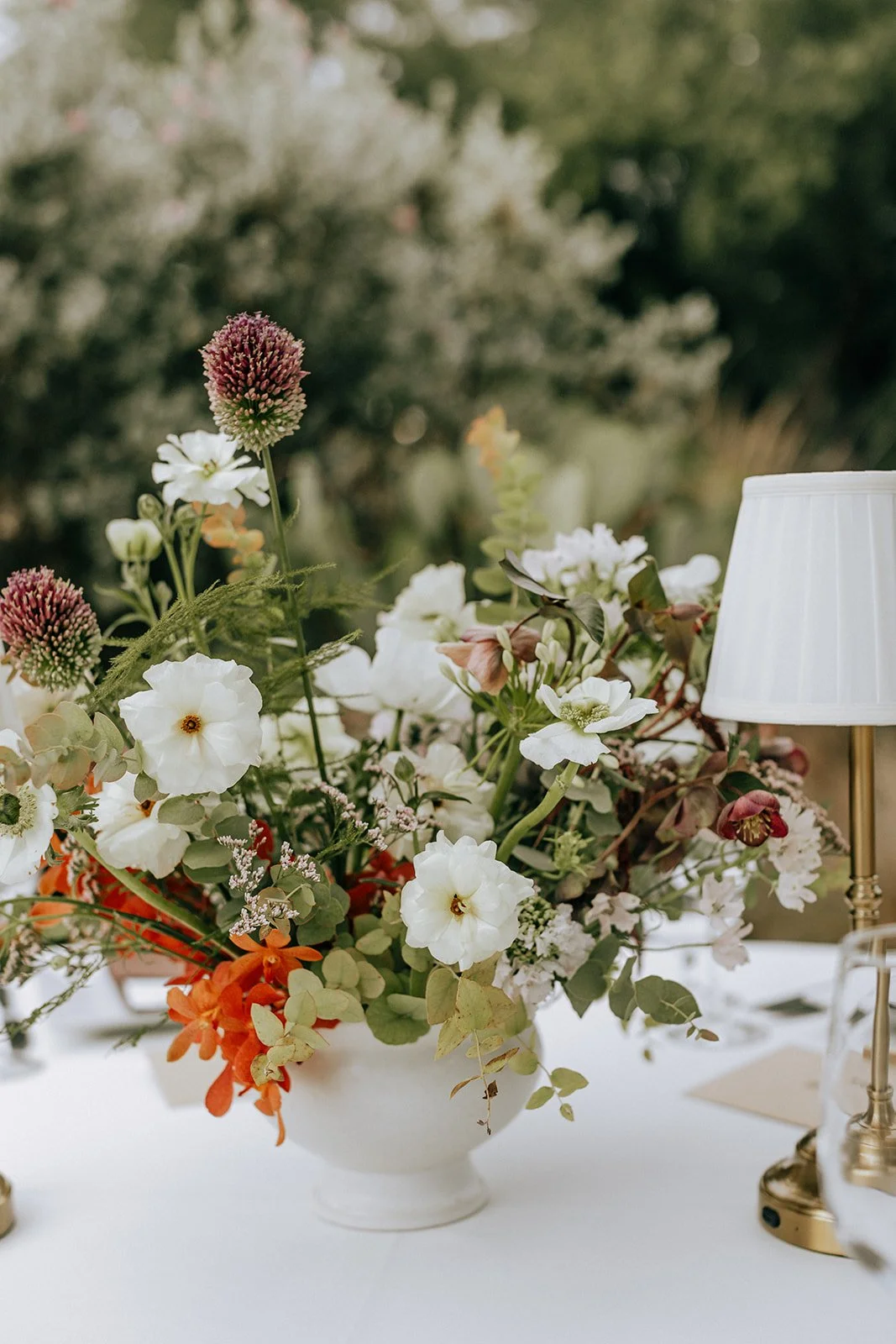  Western inspired fall wedding colors were chosen for this floral design in a white compote. 