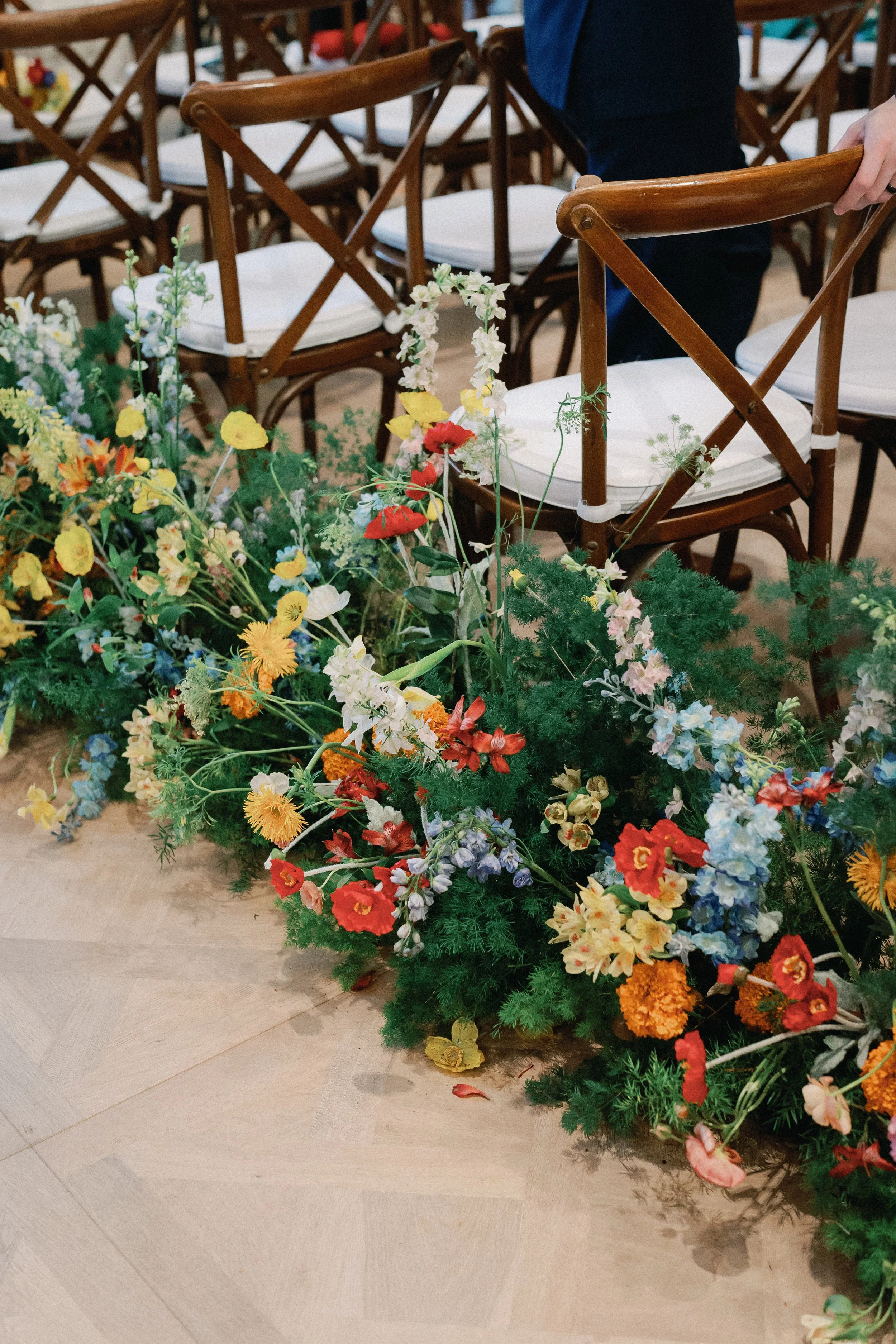  Close-up of the colorful aisle floral arrangement beside the ceremony chairs at Mattie's 