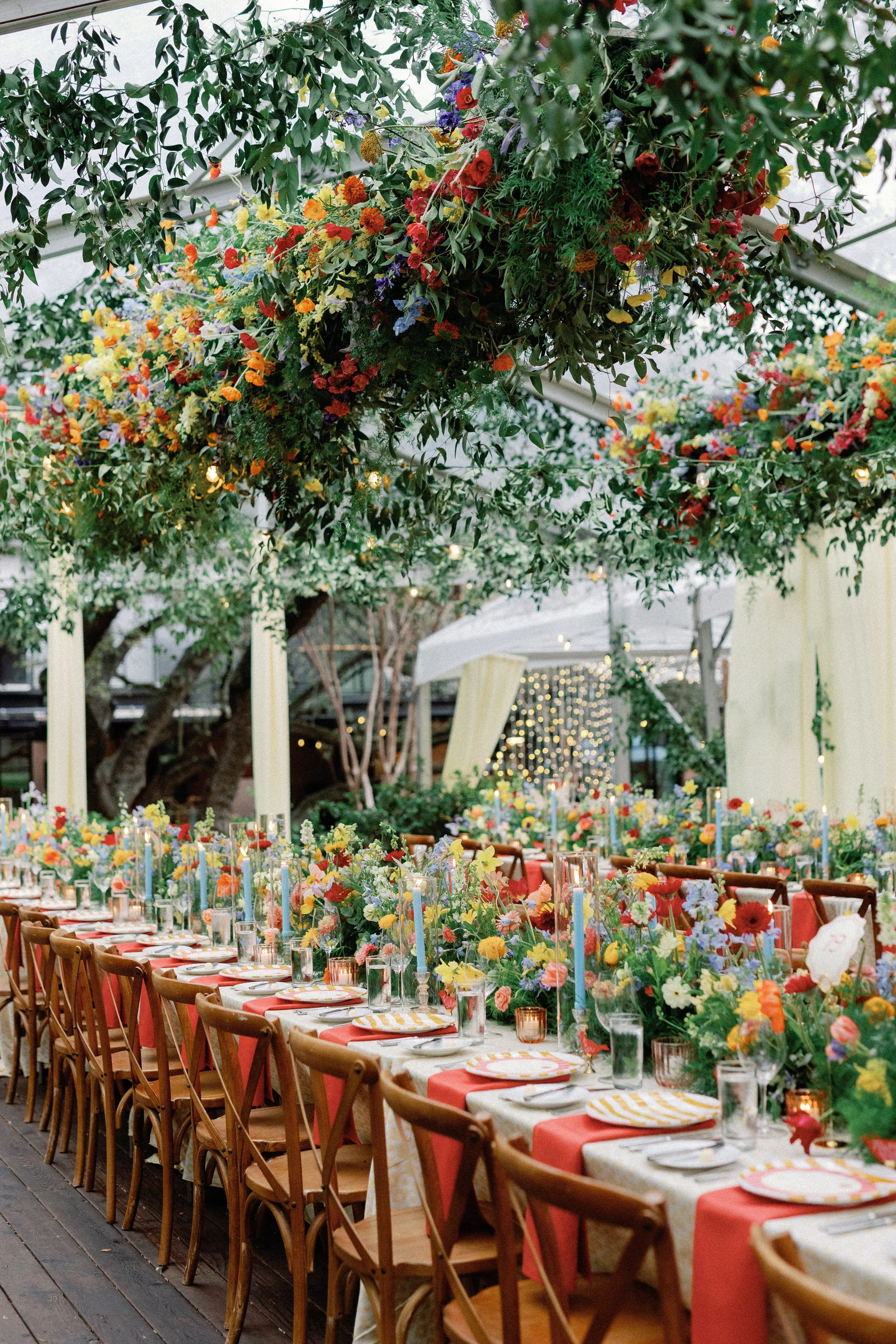  Hanging floral and greenery garland canopy over long candlelit reception tables at Mattie's 