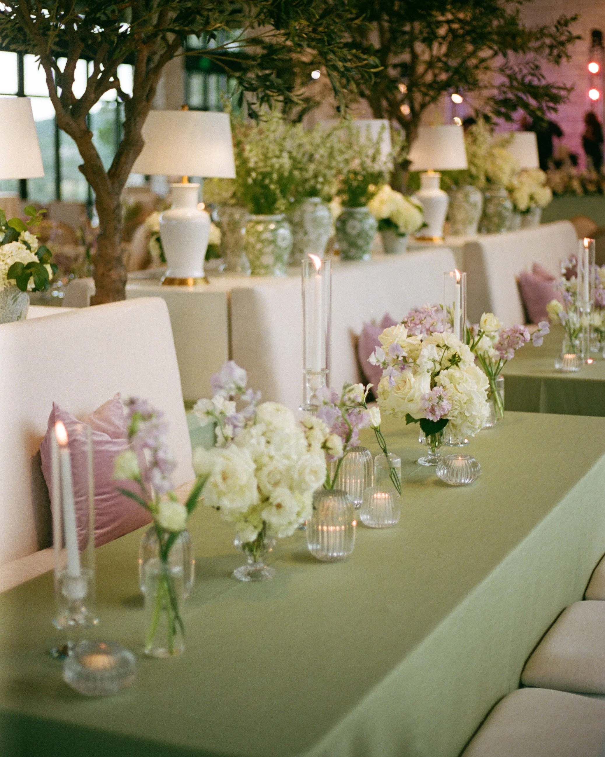  Close up of sage green table runner with lavender floral accents and taper candles at Austin wedding reception 